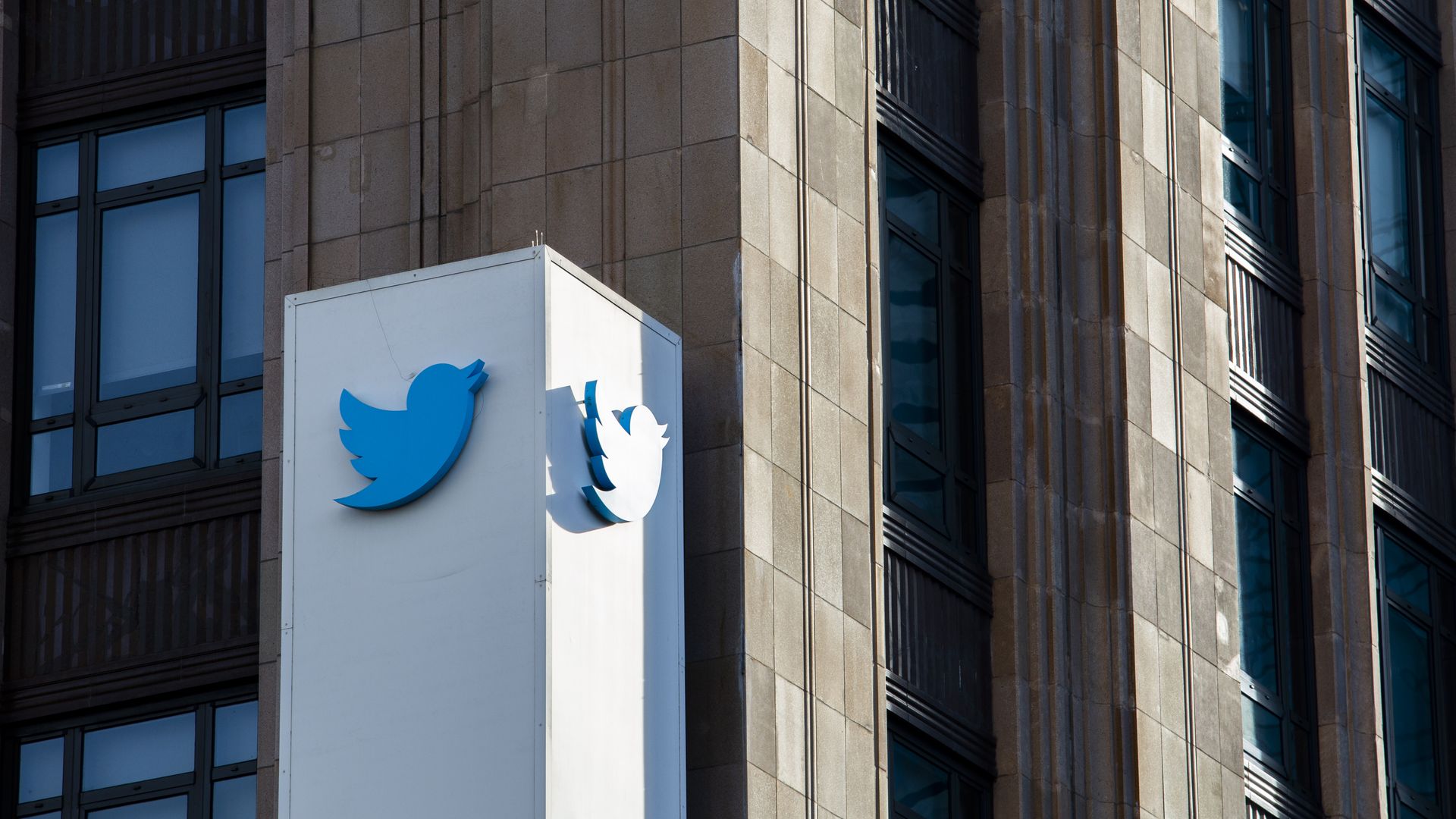 Photo of Twitter's blue bird logo on the exterior of a building