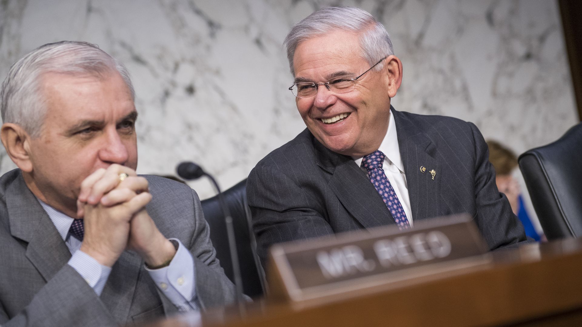Sens. Jack Reed and Bob Menendez are seen laughing at a joint Senate hearing.