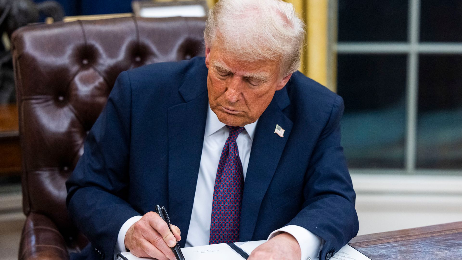 A photo of President Donald Trump signing a document.