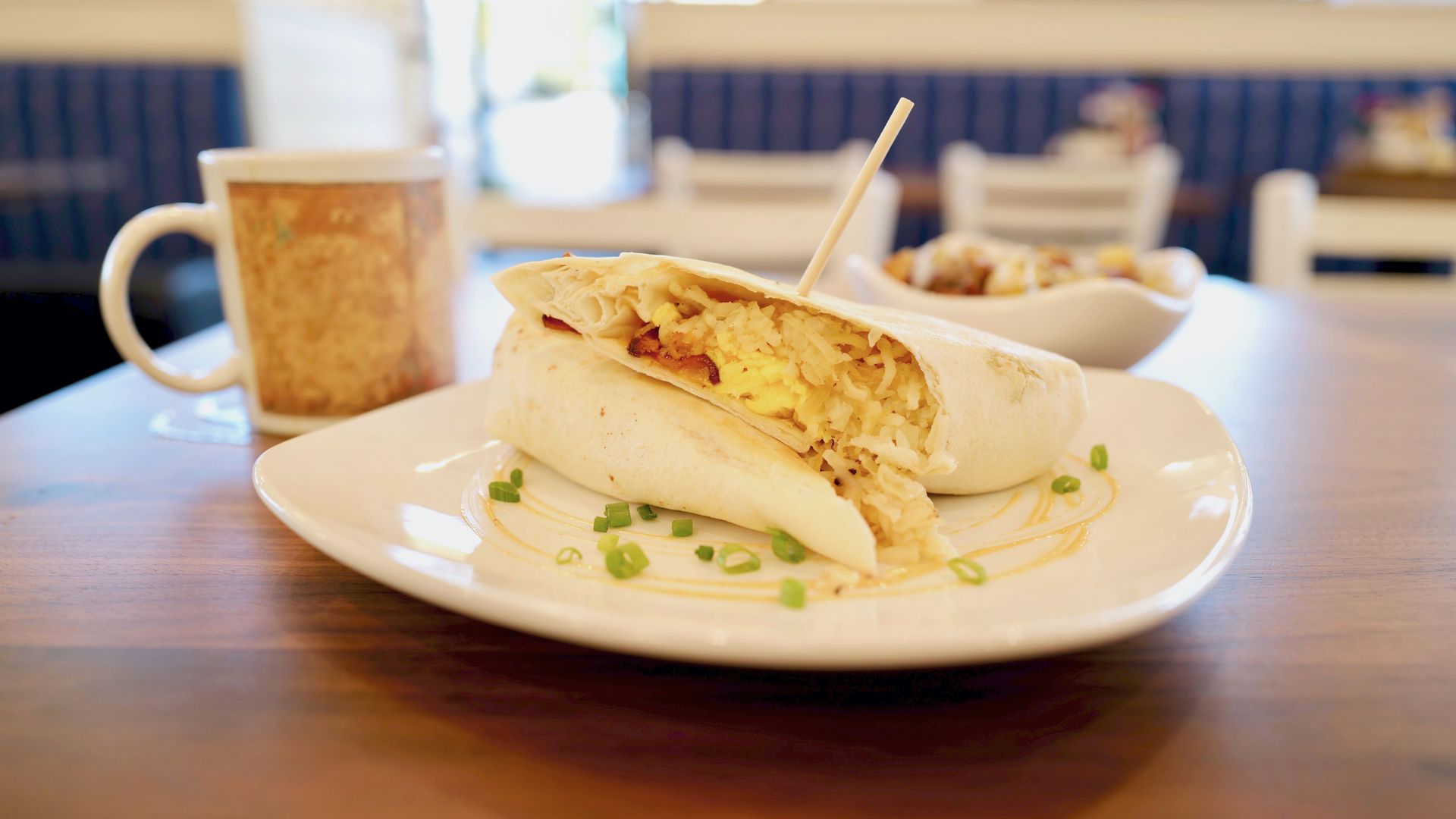 A breakfast burrito on a plate. 
