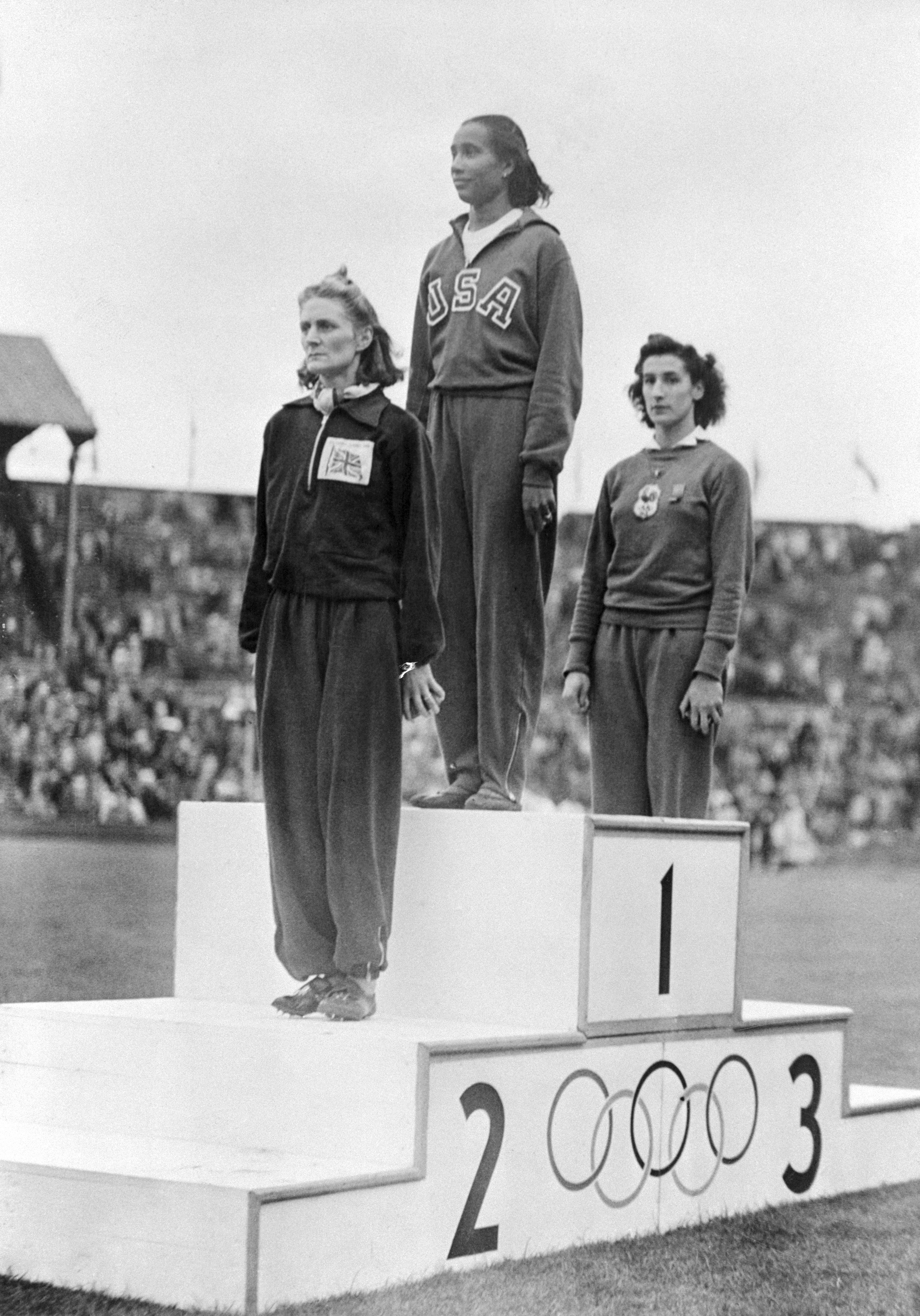 Alice Coachman, (C) of the US, along with the winner DJ Tyler (L), of Great Britain, and MOM Ostermeyer, of France, stand on a podium at Wembley Stadium to receive their awards for the Olympic women's high jump, London, England 8/7/1948. Coachman was the first black woman to win an Olympic gold medal. (Photo by Bettmann via Getty Images)