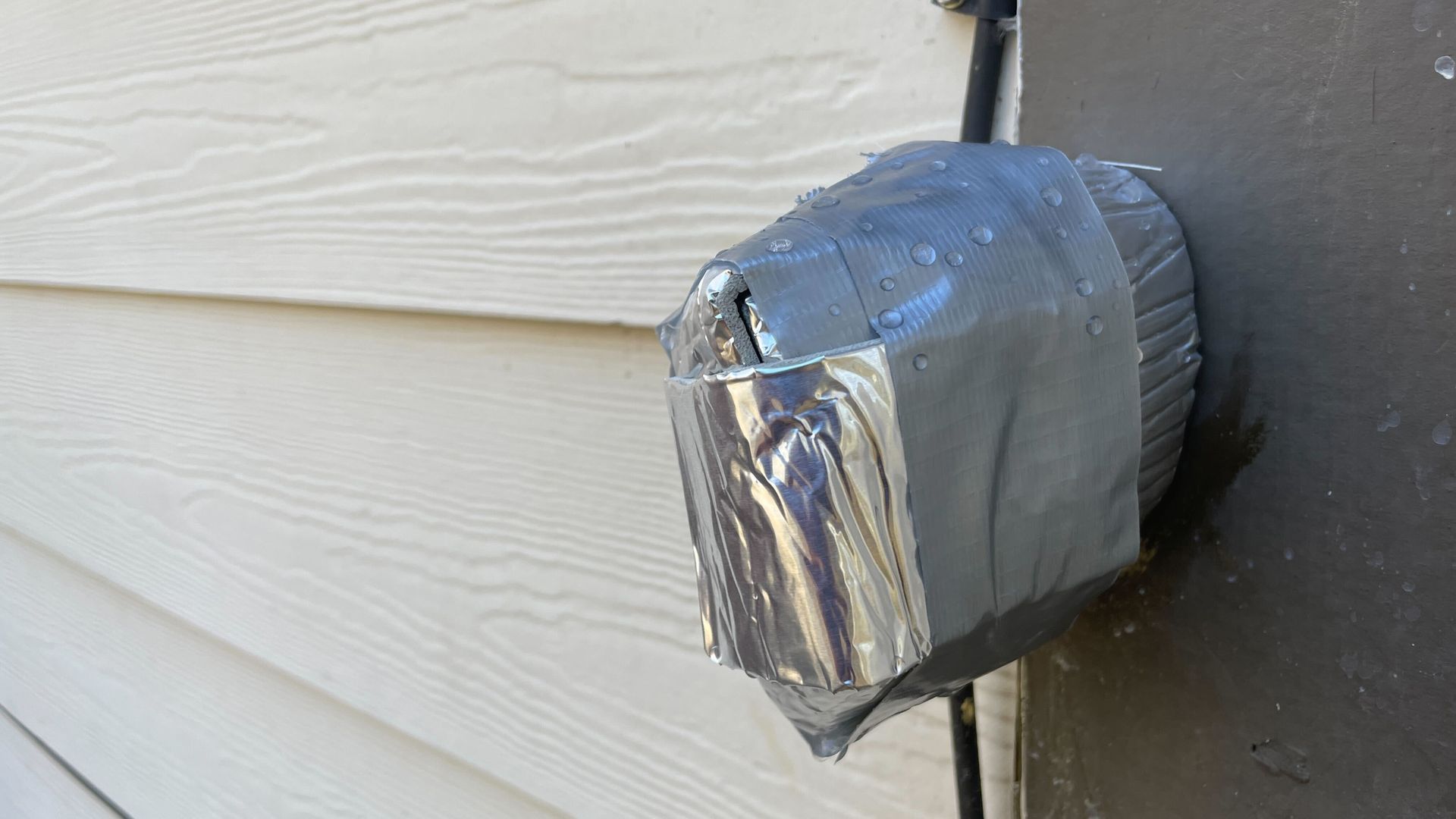  Image of duct tape wrapped around several layers of foam and foil pipe wrap insulation tape that is applied to an outdoor faucet to prevent it from freezing.