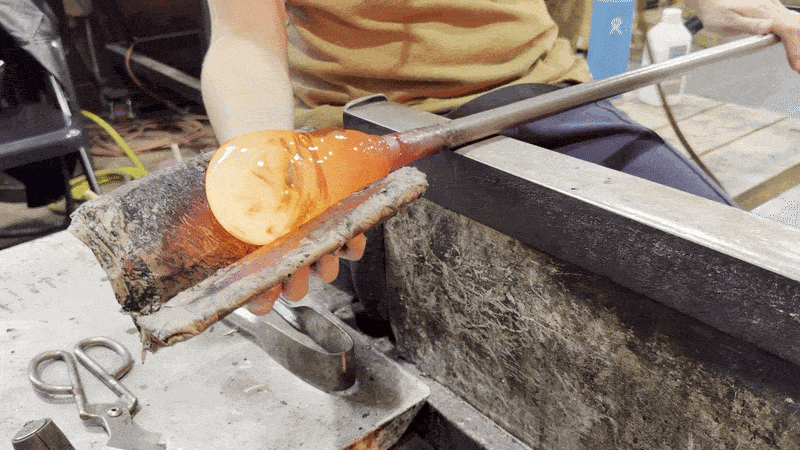 Animated gif shows a molten piece of glass in the process of glass blowing.