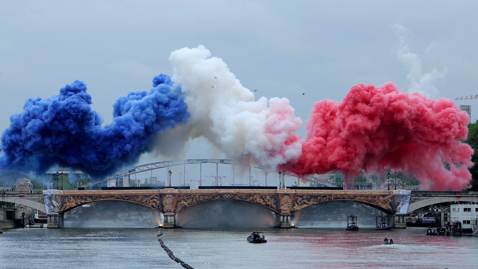 Smoke clouds in the tricolours of the France flag are seen at Pont d'Austerlitz during the Opening Ceremony of the Olympic Games Paris 2024 on July 26, 2024 in Paris, France. (Photo by Ann Wang - Pool/Getty Images)
