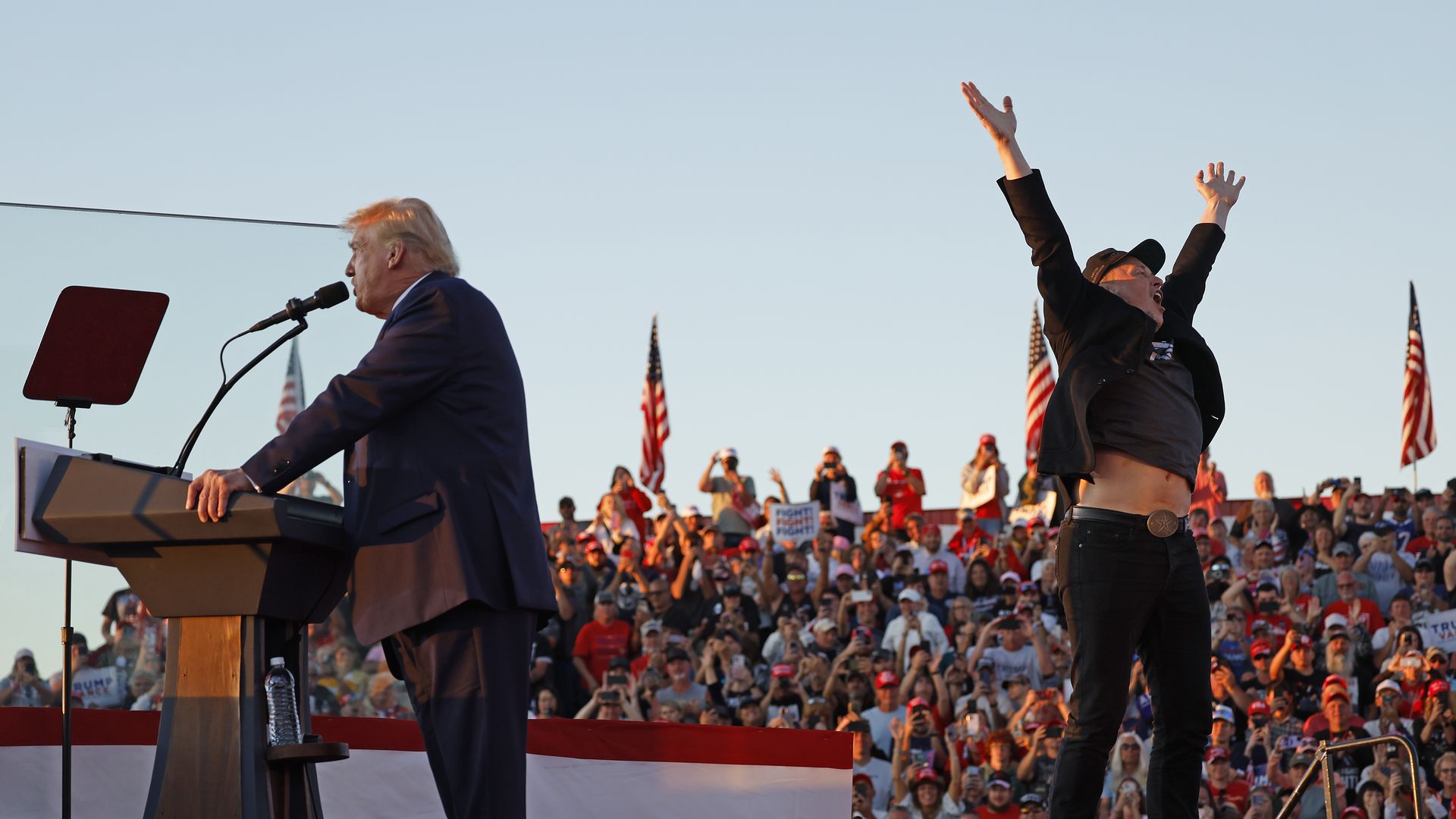 Elon Musk leaps on stage with Republican presidential nominee, former President Donald Trump during a campaign rally from behind bullet resistant glass at the Butler Farm Show fairgrounds on October 05, 2024 in Butler, Pennsylvania. 