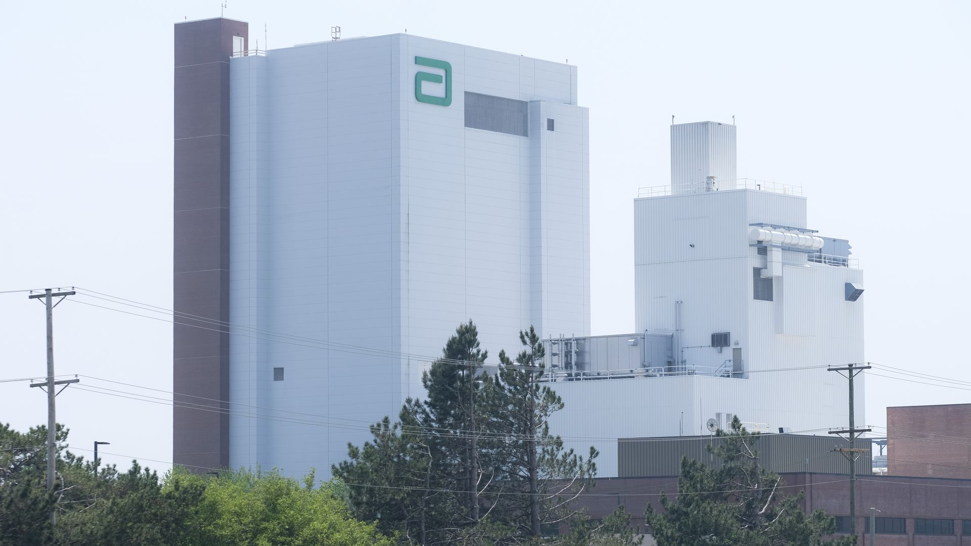 A boxy white factory rises several stories high