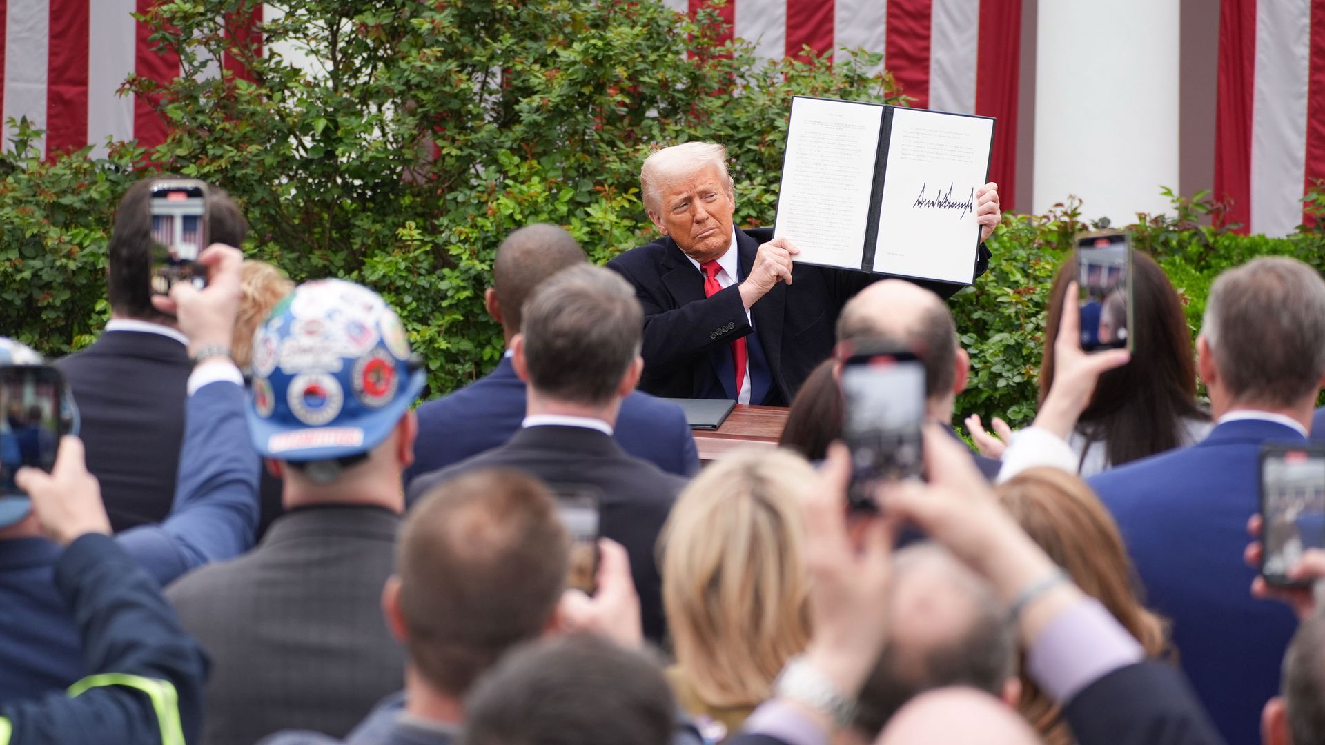 President Trump in the White House Rose Garden, holding up an order he'd just signed. 