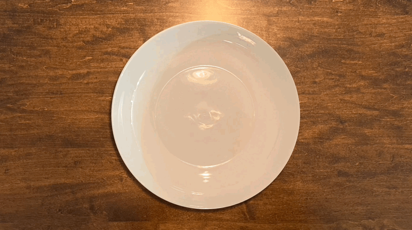 An animation of two donut halves appearing and disappearing on a plate on a wooden table