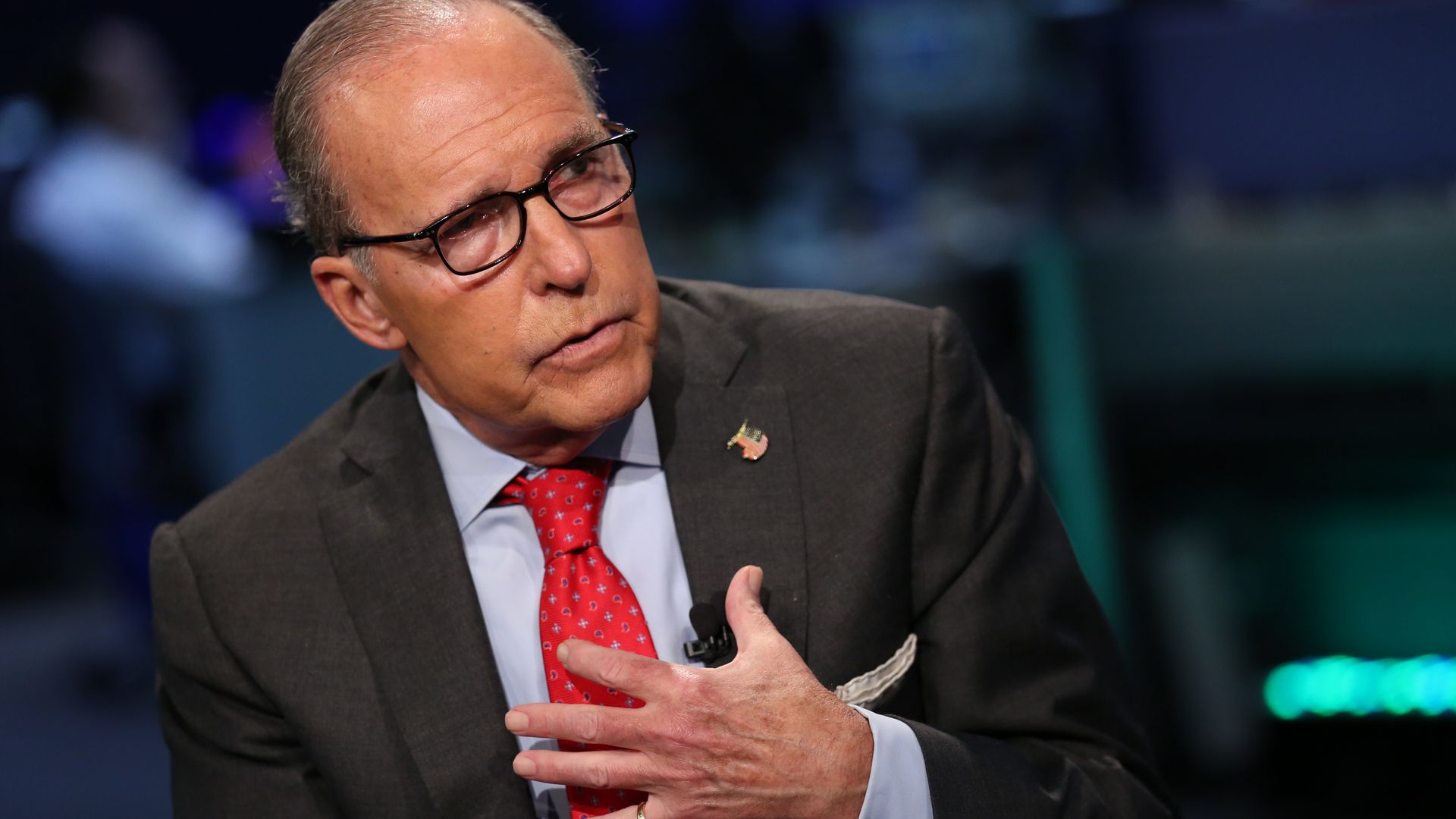 Larry Kudlow wearing a suit with red tie. 