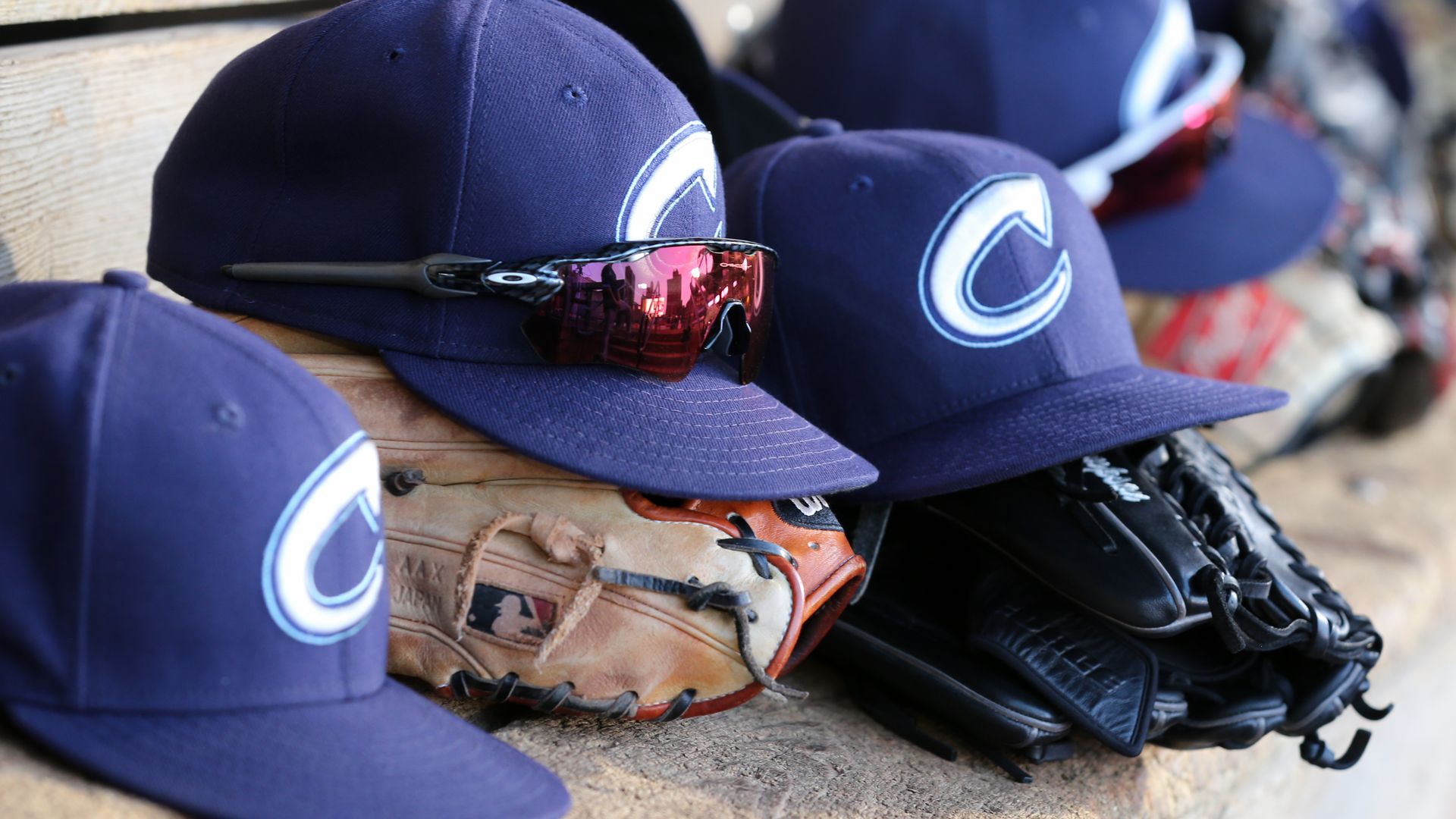 Columbus Clippers baseball hats and gloves on a dugout bench. 