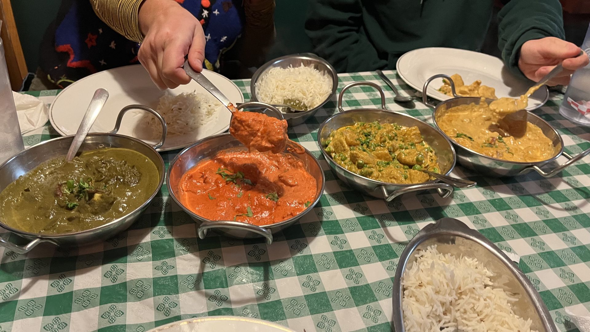 Four dishes left to right, palak paneer, tikki masala, mattar and peanut butter chicken