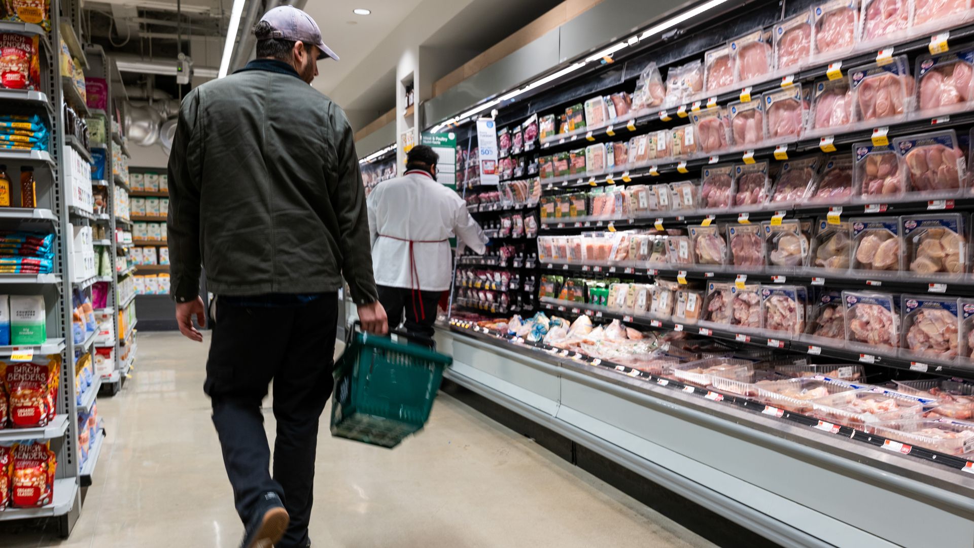 Shopper walks down the meat aisle in a grocery store