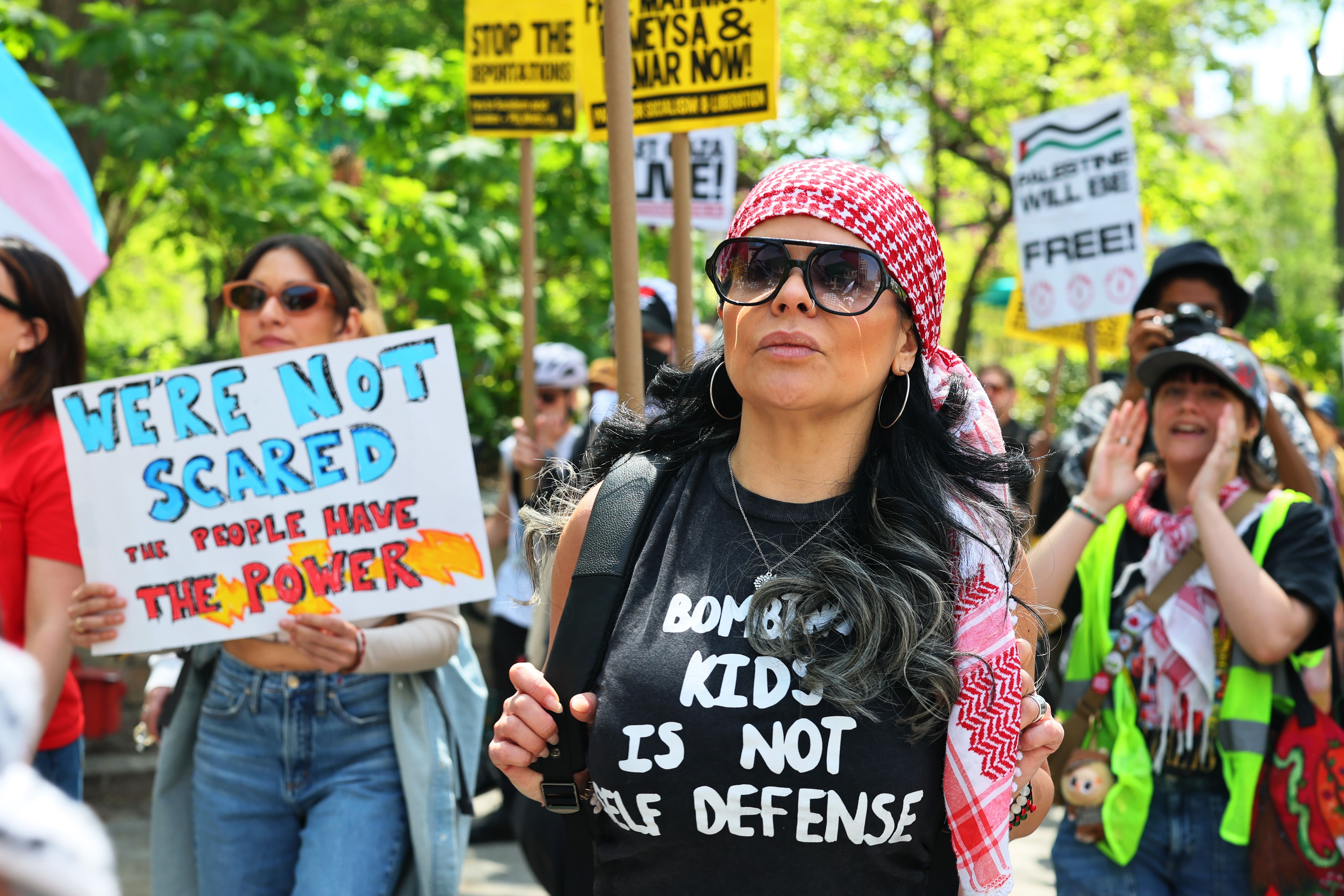 A person photographed wearing a shirt that reads "bombing kids is not self defense" 