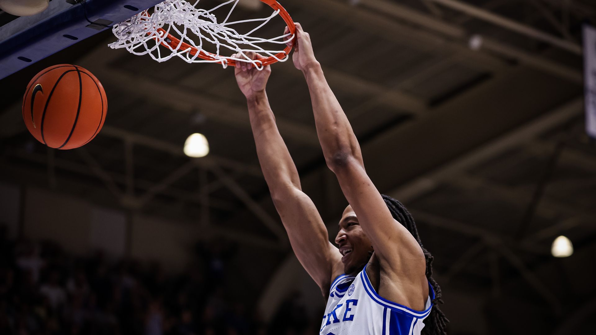 Maliq Brown #6 of the Duke Blue Devils smiles as he dunks the ball during a game at Cameron Indoor Stadium. It's a tight shot, from chest up.