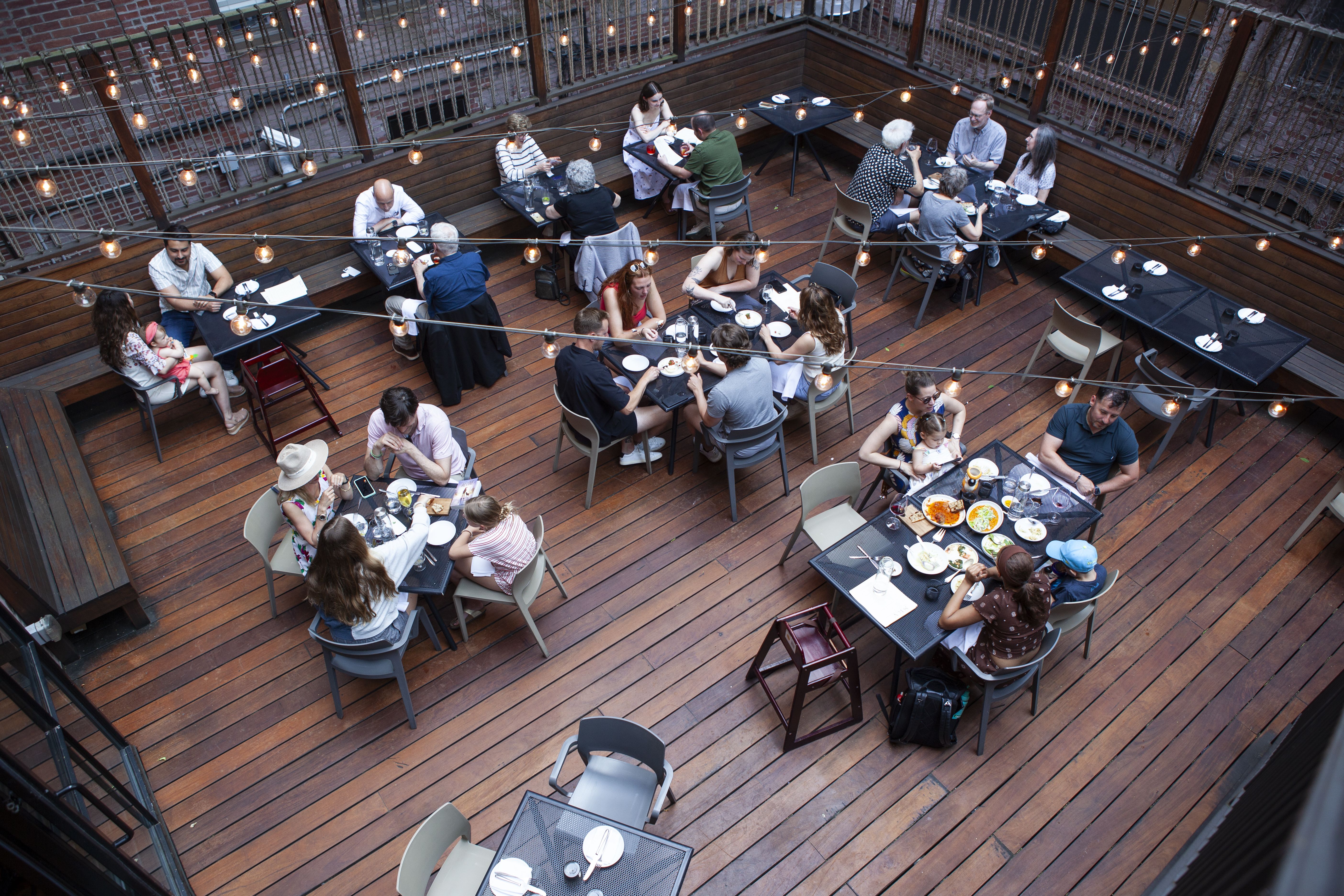 An aerial view of several dining tables in an outdoor patio at SRV in Boston's South End.