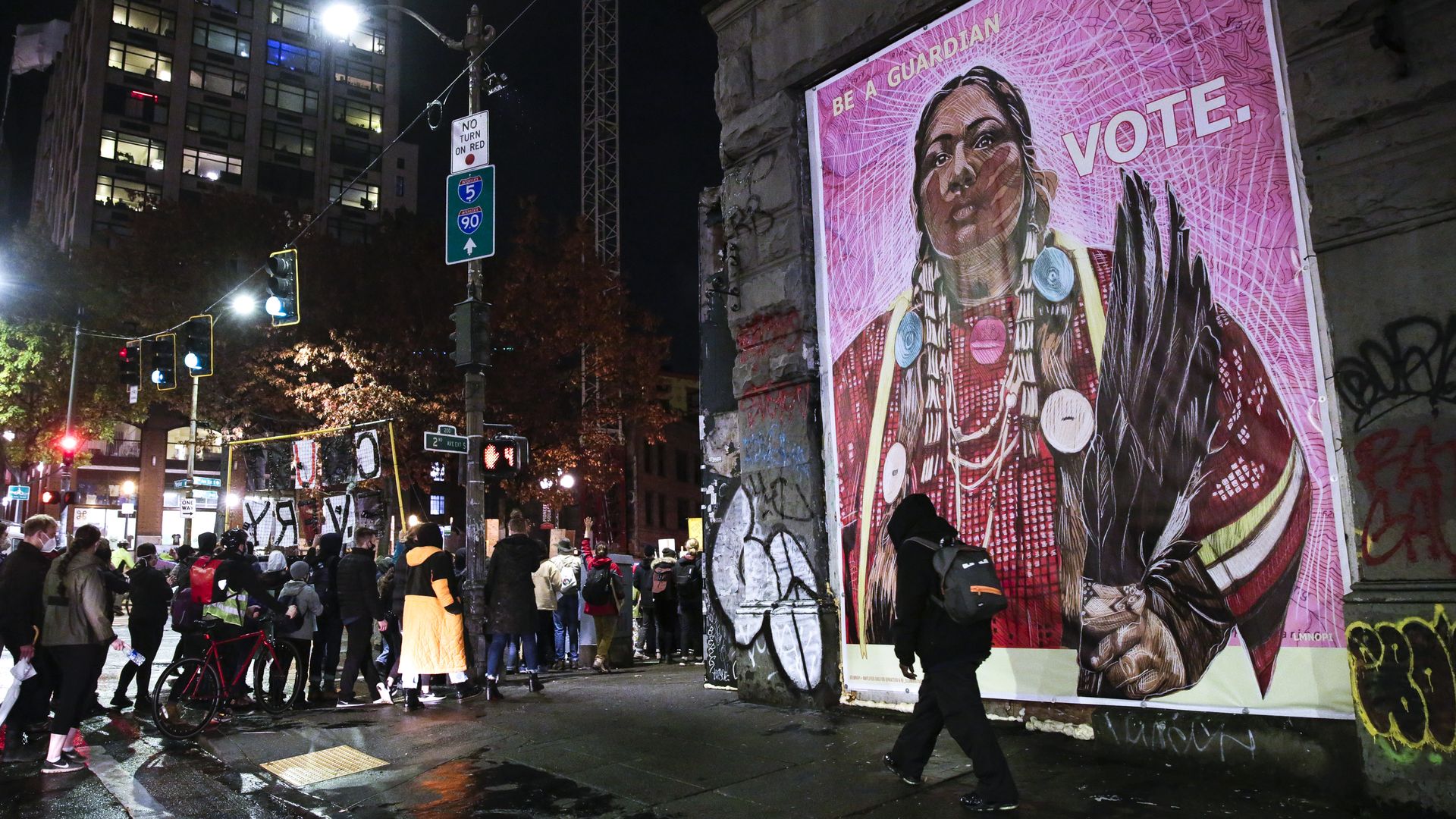 Protestors walk past an image of a Native American woman during a march to "Count Every Vote, Protect Every Person" on the day after the US Presidential Election in Seattle.