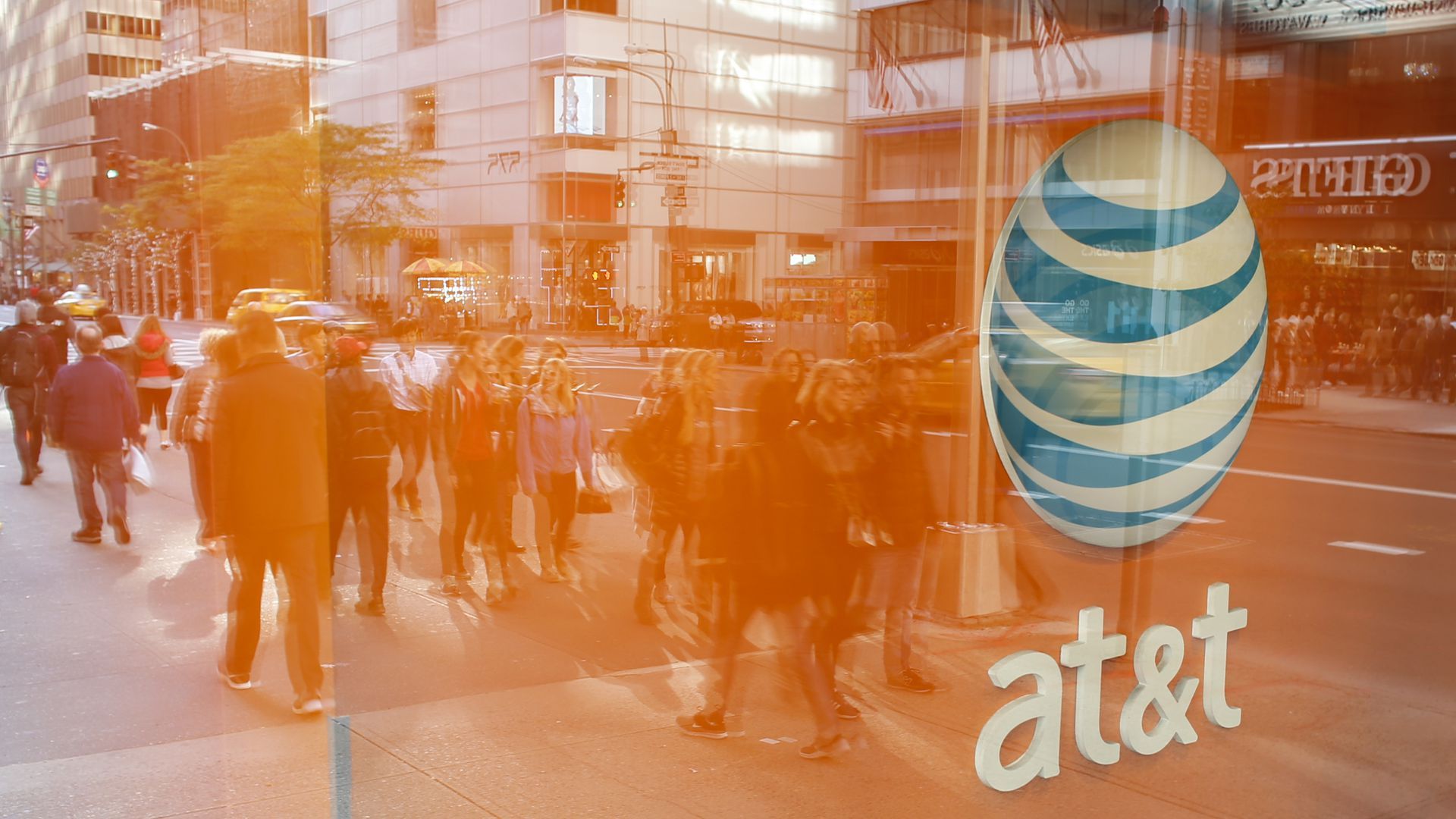 AT&T logo on window as pedestrians walk by