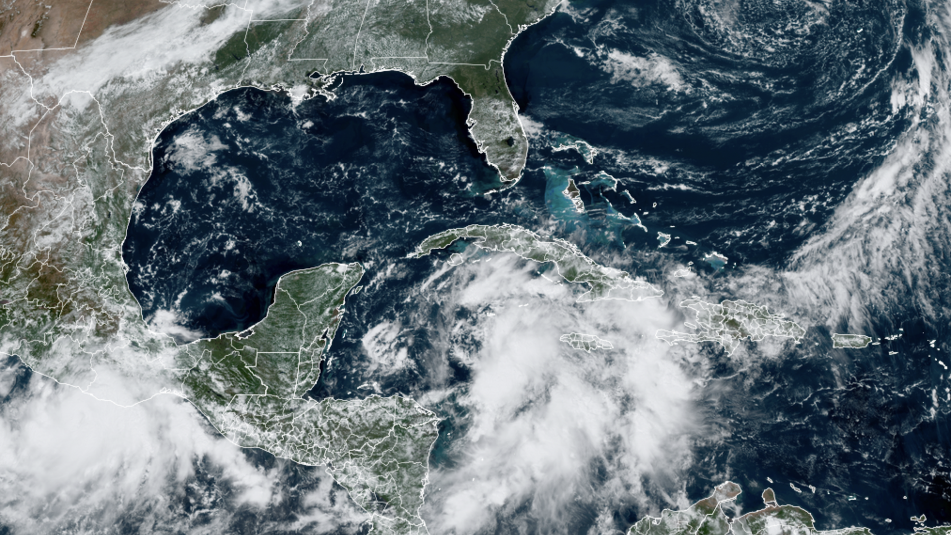 Image shows a satellite view of a tropical system in the Caribbean.