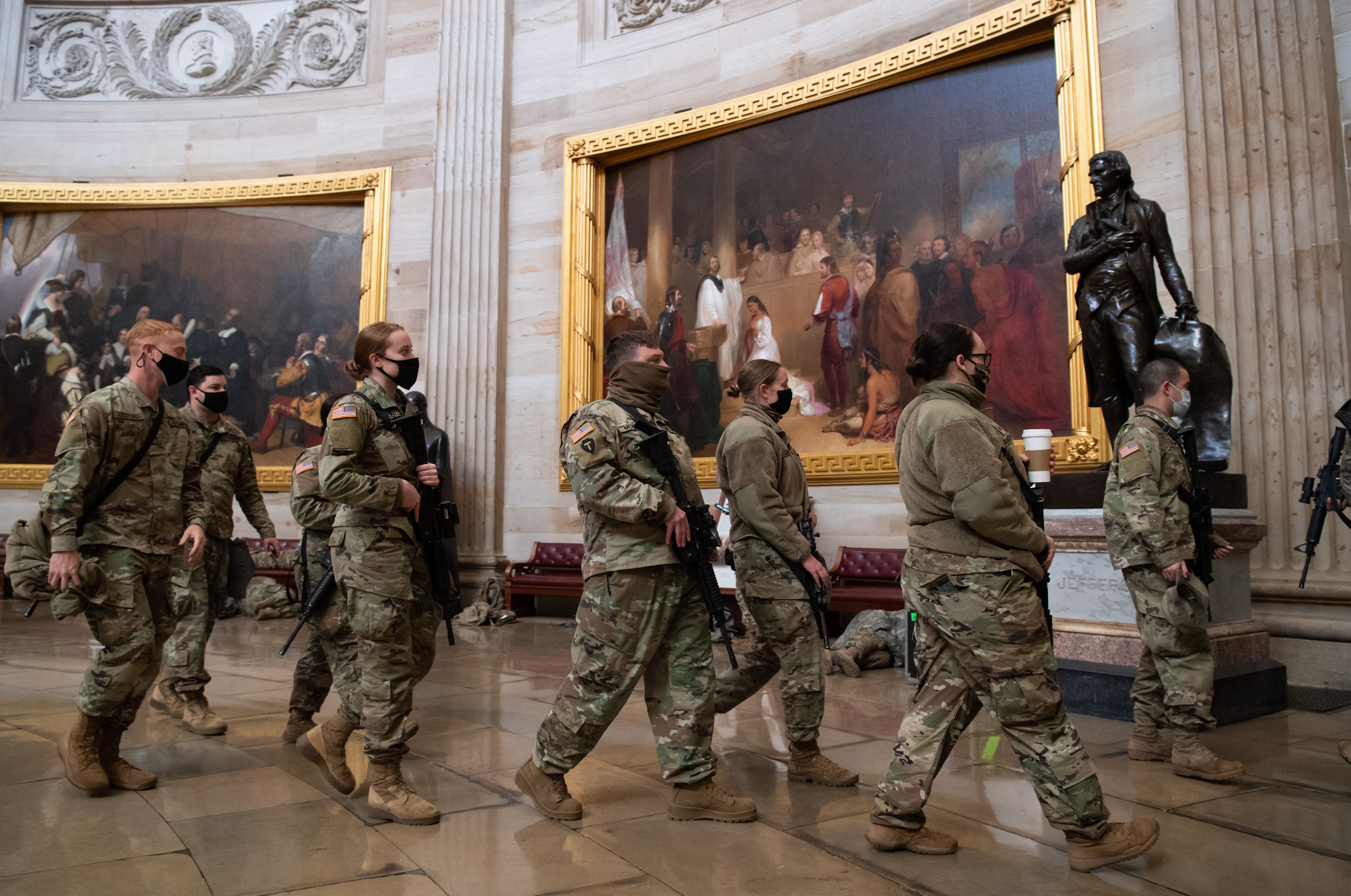 Members of the National Guard walk through the Rotunda of the US Capitol