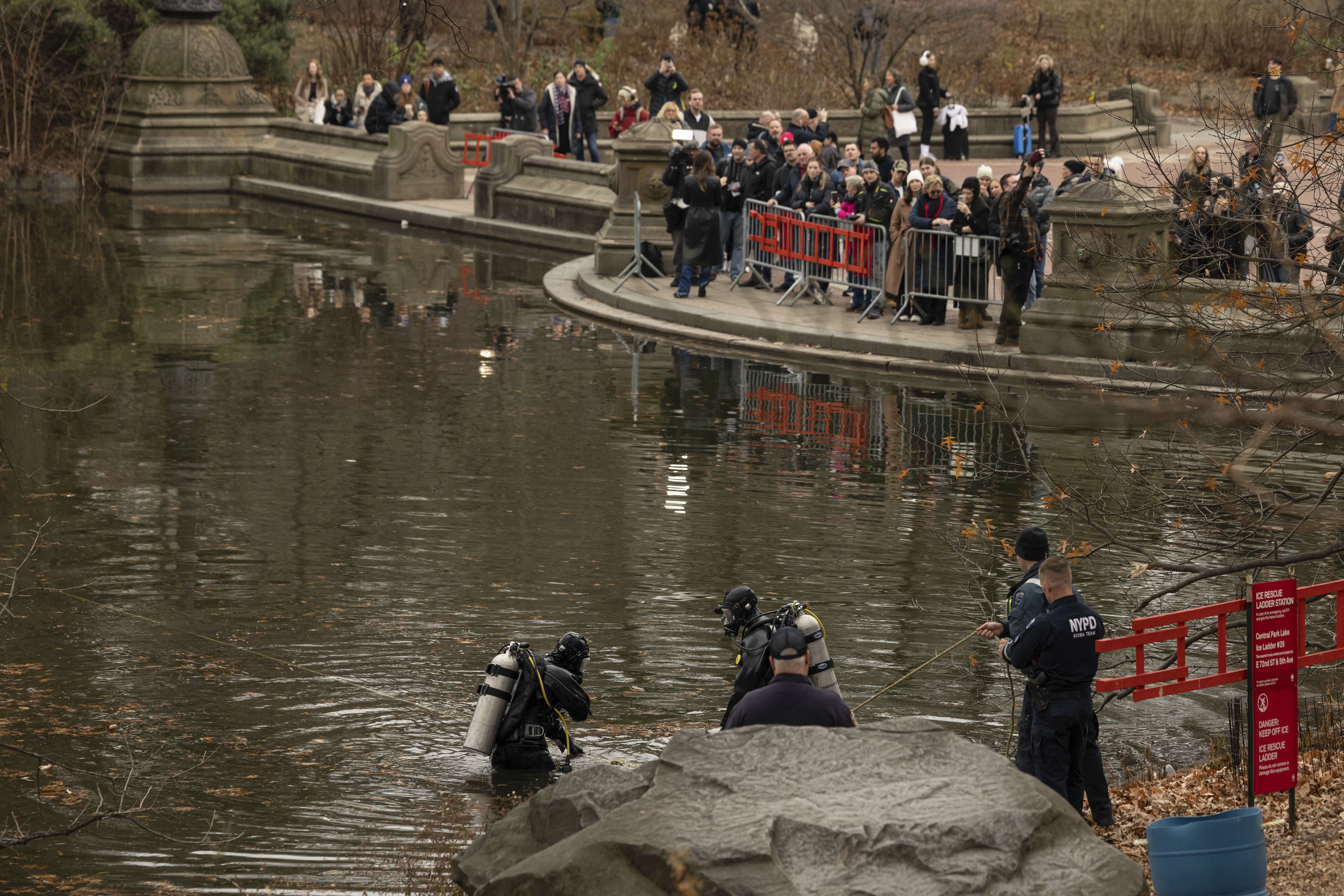 NYPD officers in diving suits search a lake in Central Park today. Photo: Yuki Iwamura/AP