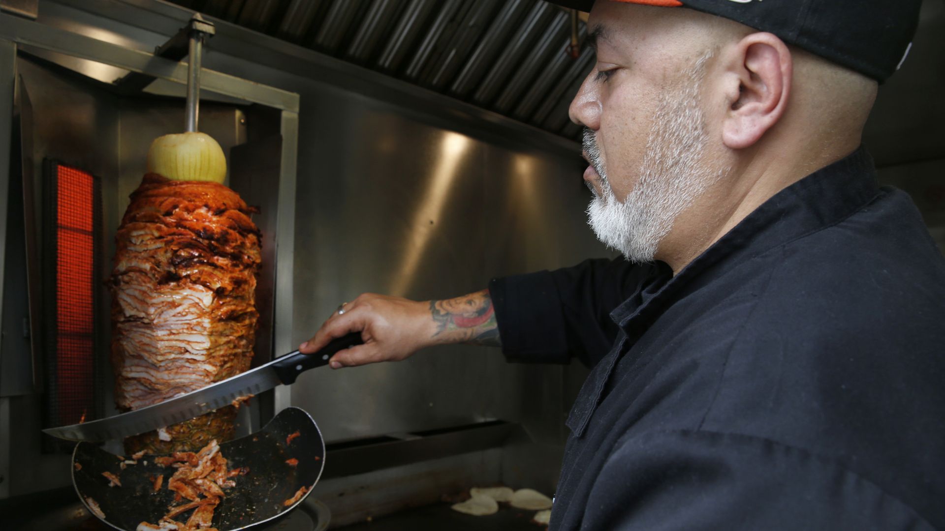 Photo of a chef slicing meat over a pan