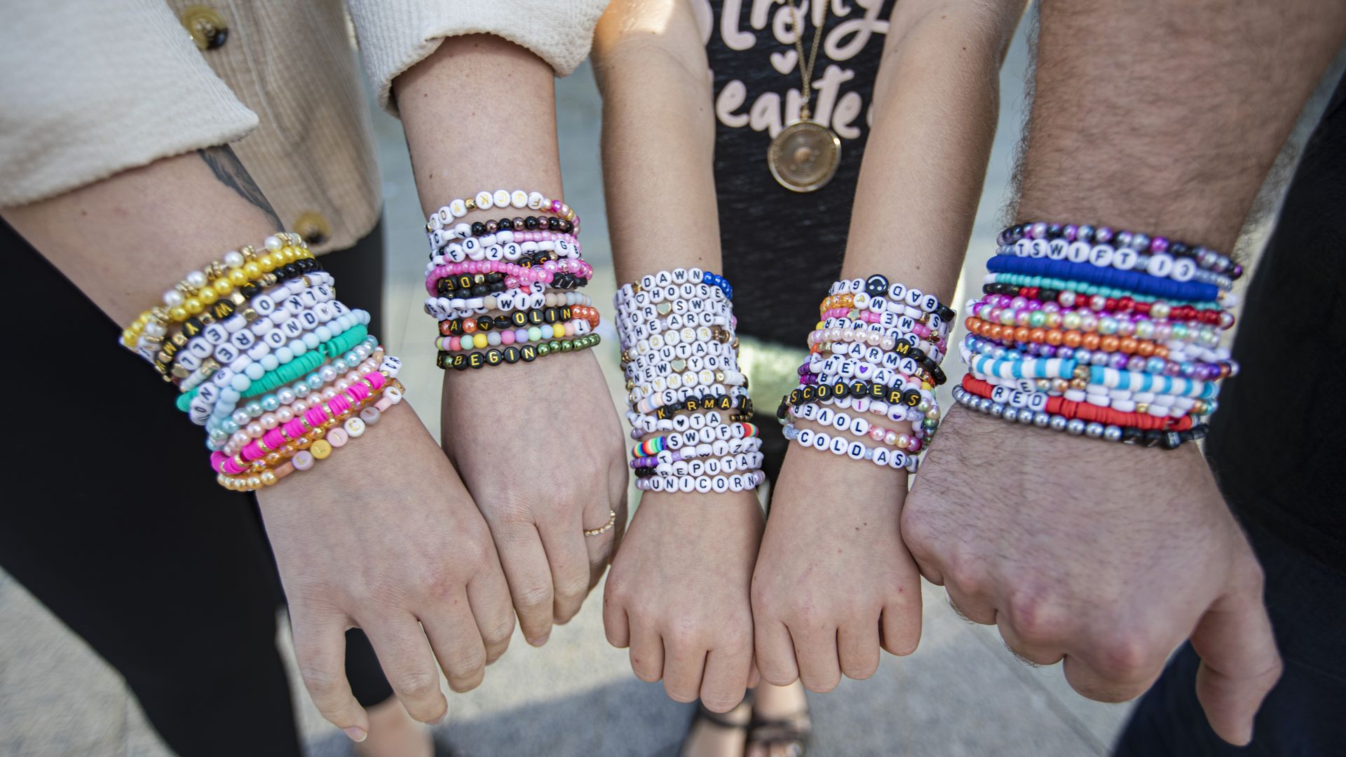 A photo of hands wearing friendship bracelets to a taylor swift concert