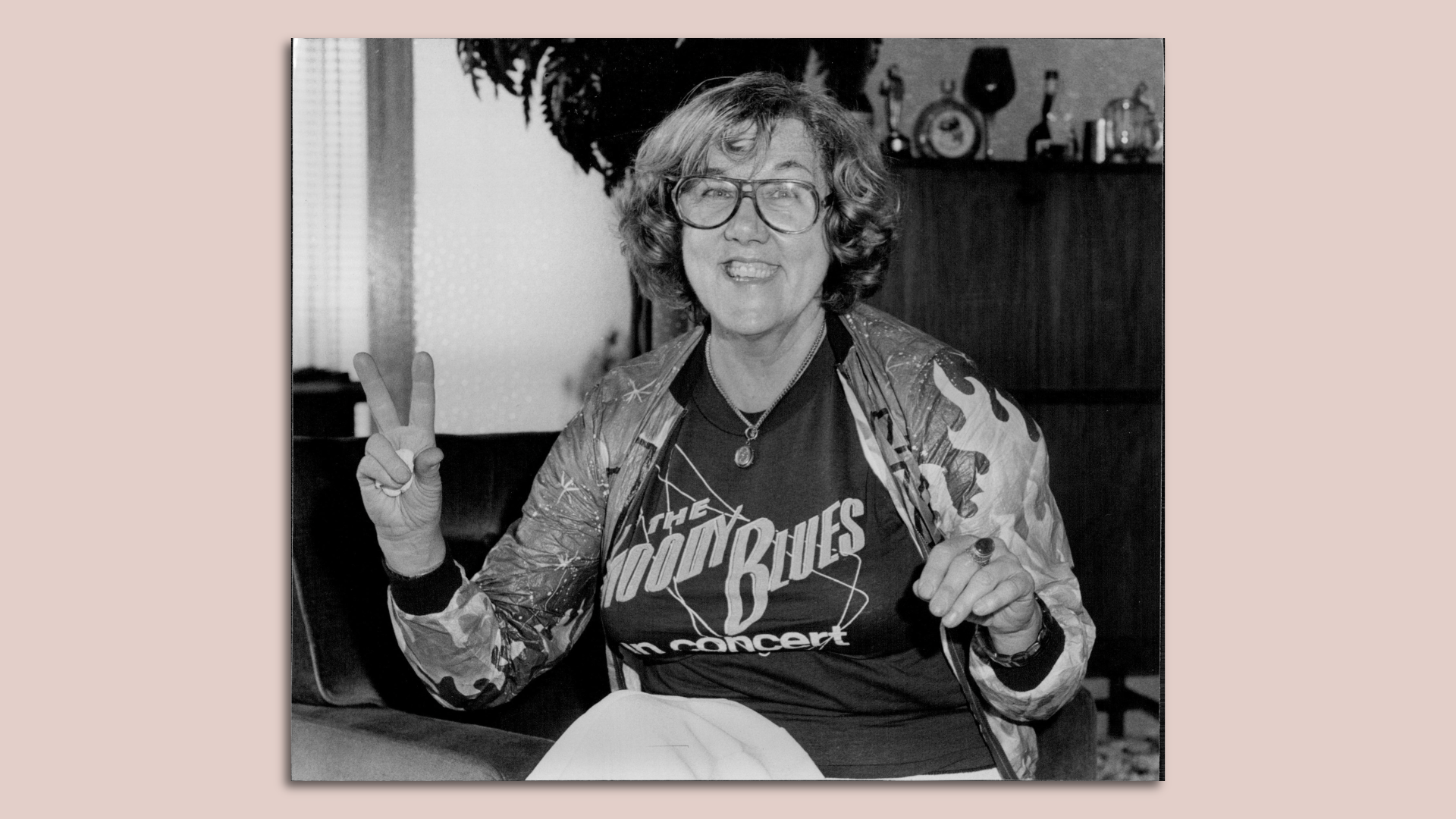 Black and white image of Jane Scott flashing a peace sign.