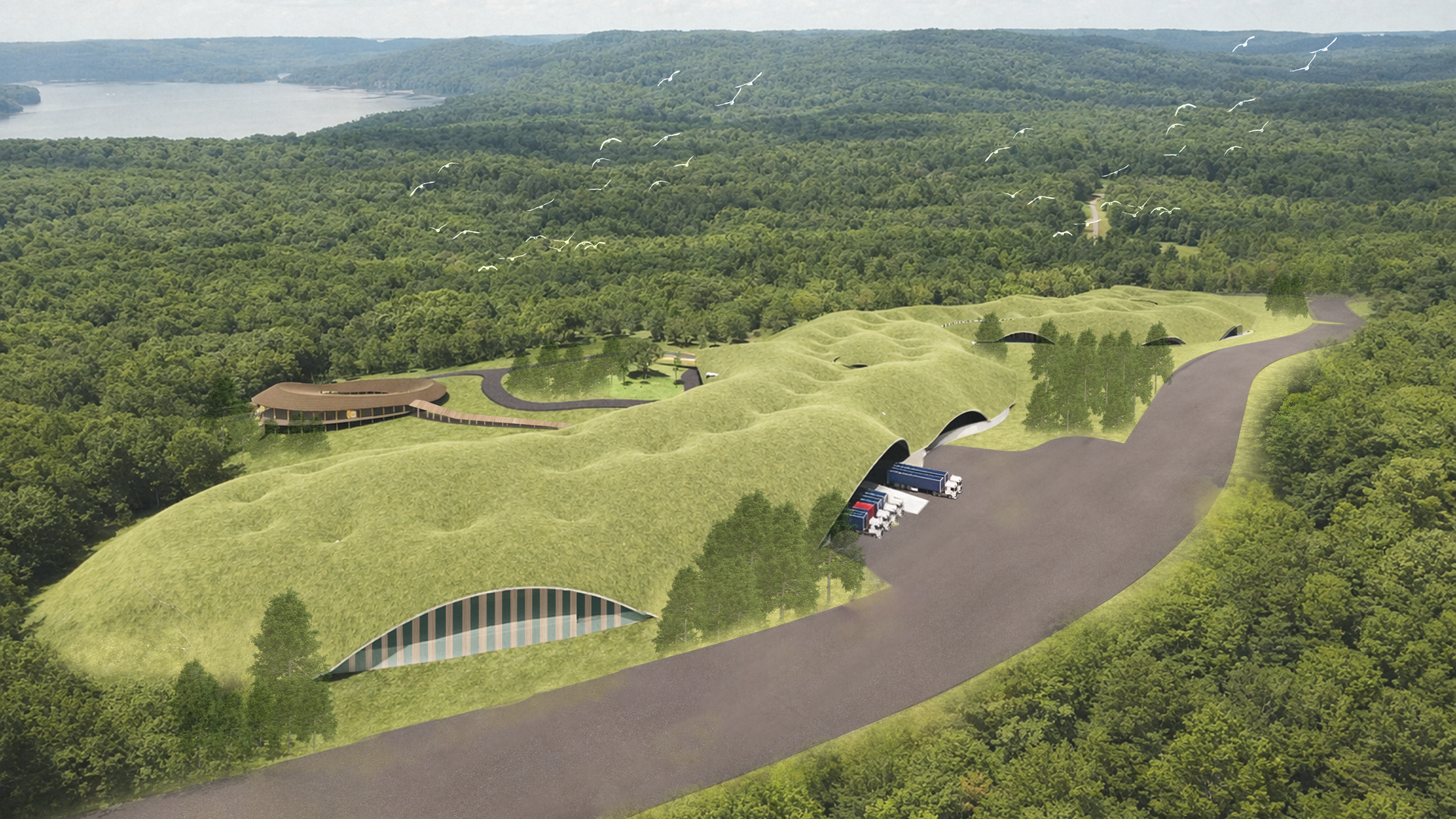 Aerial view of rolling green hills with tunnel arches and trucks at the entrances. A winding road runs through a forested landscape toward a distant lake, while a flock of white birds flies overhead.