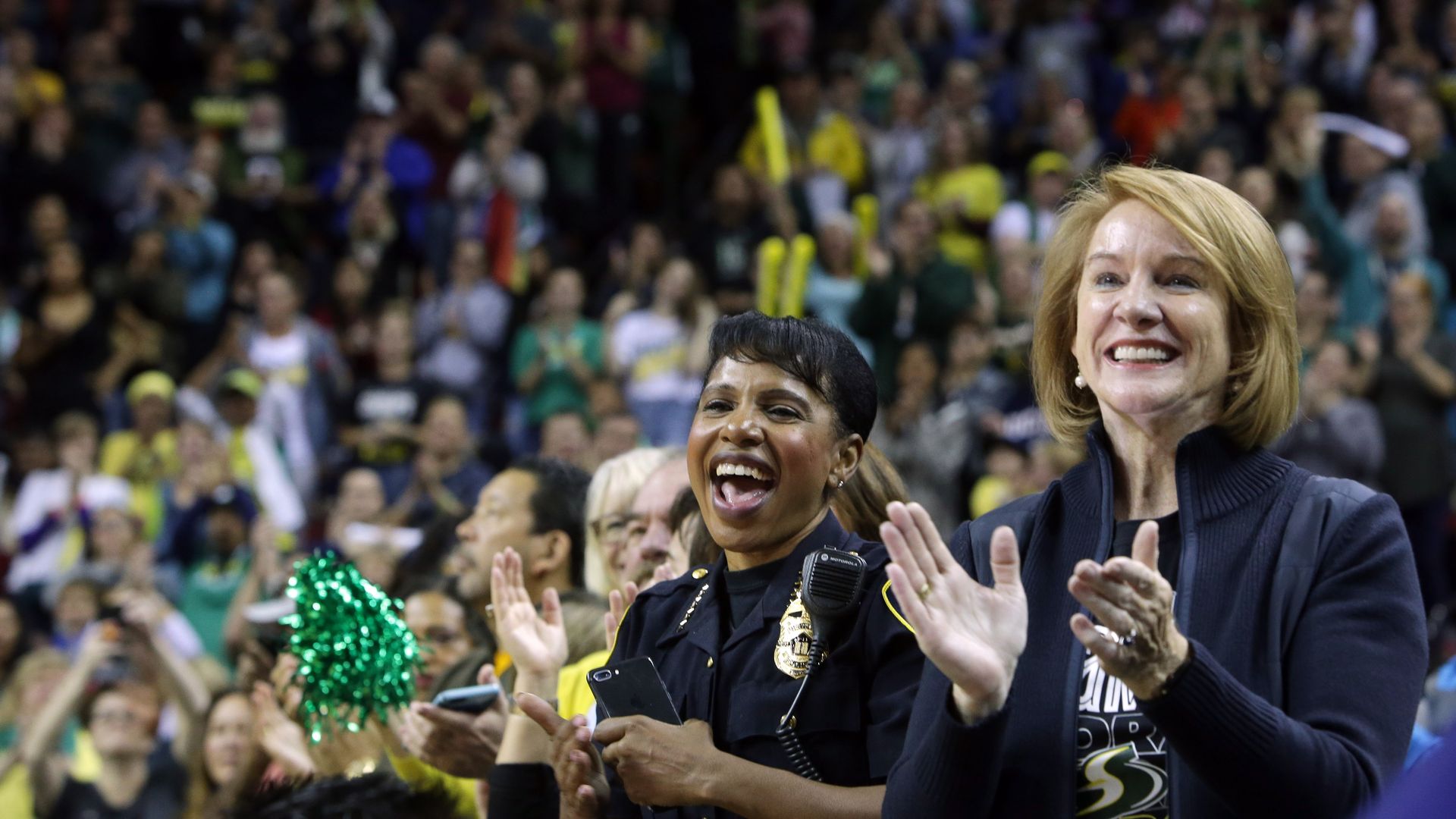 Image of former Seattle Mayor Jenny Durkan with ex-police chief Carmen Best cheering during a Seattle Storms basketball game.