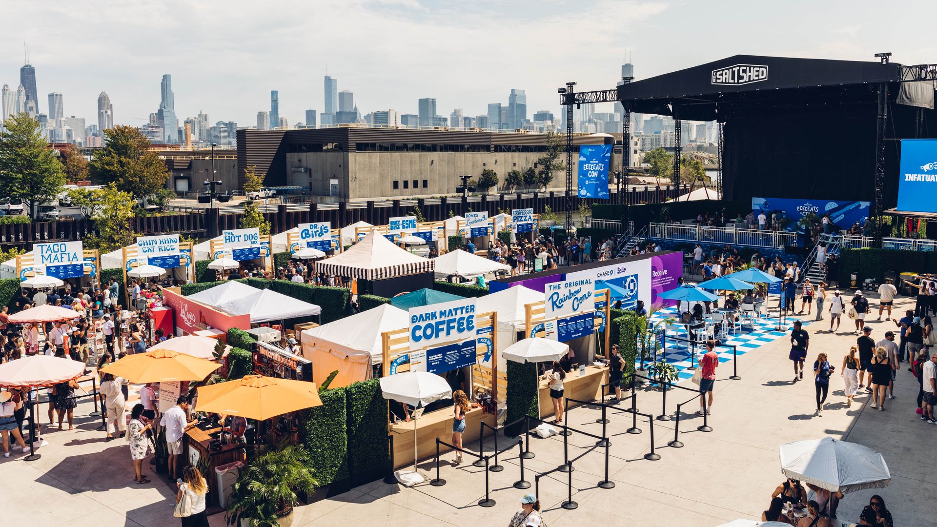 Aerial view of tents and a stage with the Chicago skyline in the background.