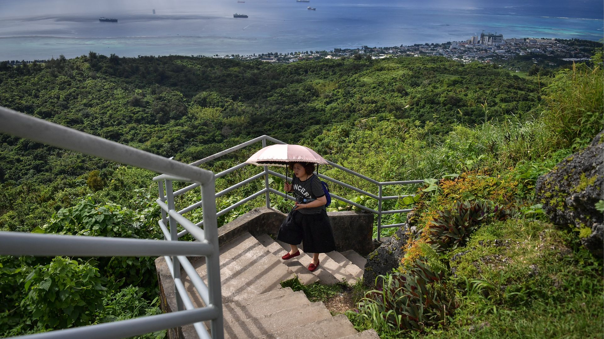 In this image, a woman walks up stairs in a forest
