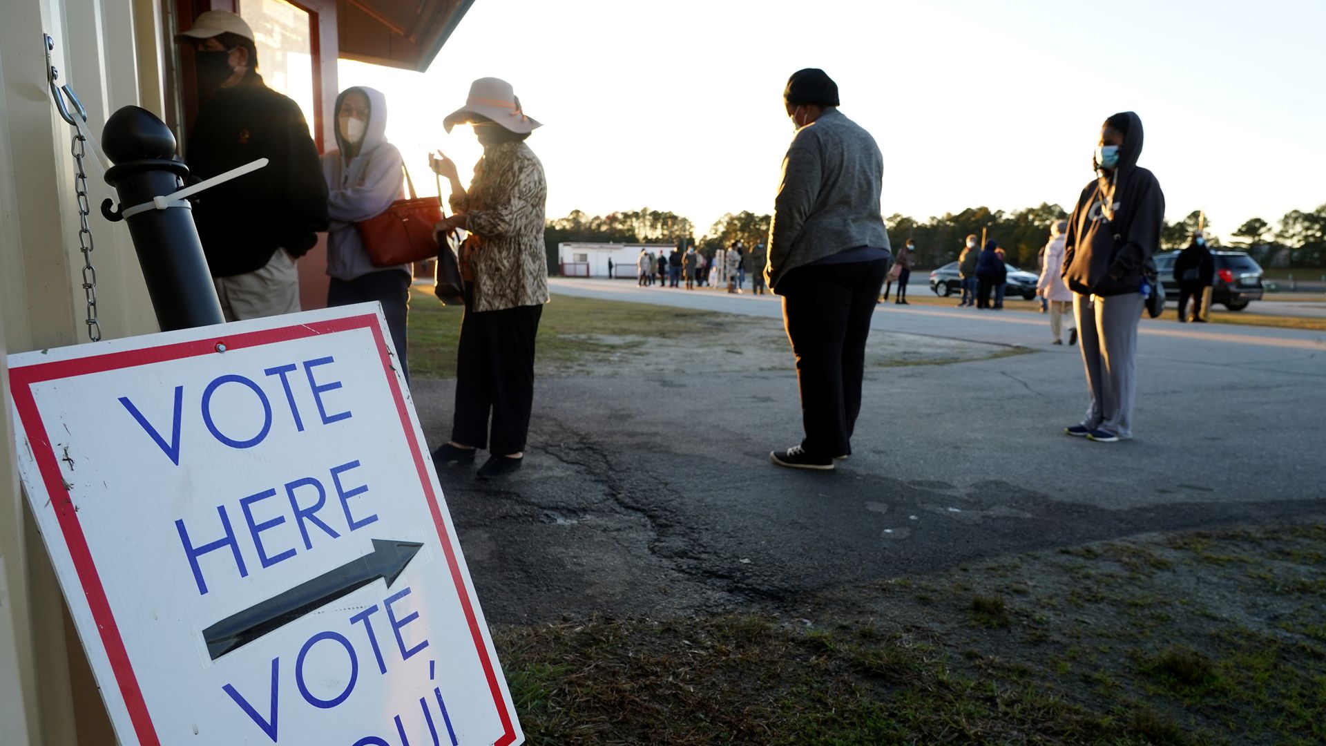  Voters stand in line to cast their ballots during the first day of early voting in the US Senate runoff at the Gwinnett Fairgrounds, December 14, 2020, in Atlanta, Georgia. 