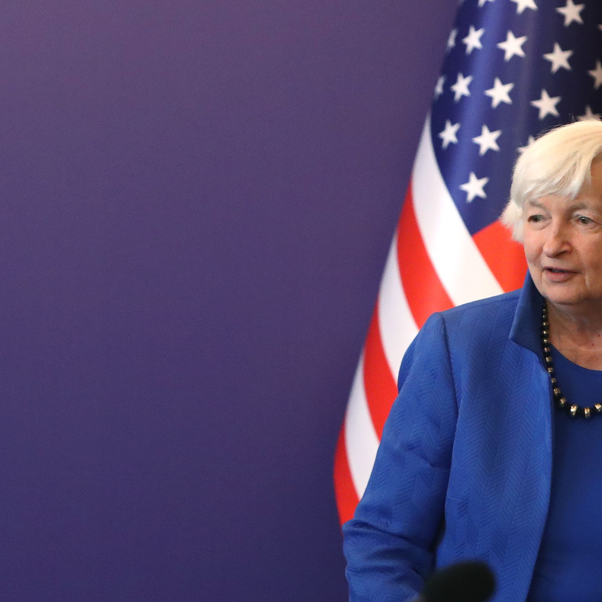 Janet Yellen standing next to an American flag