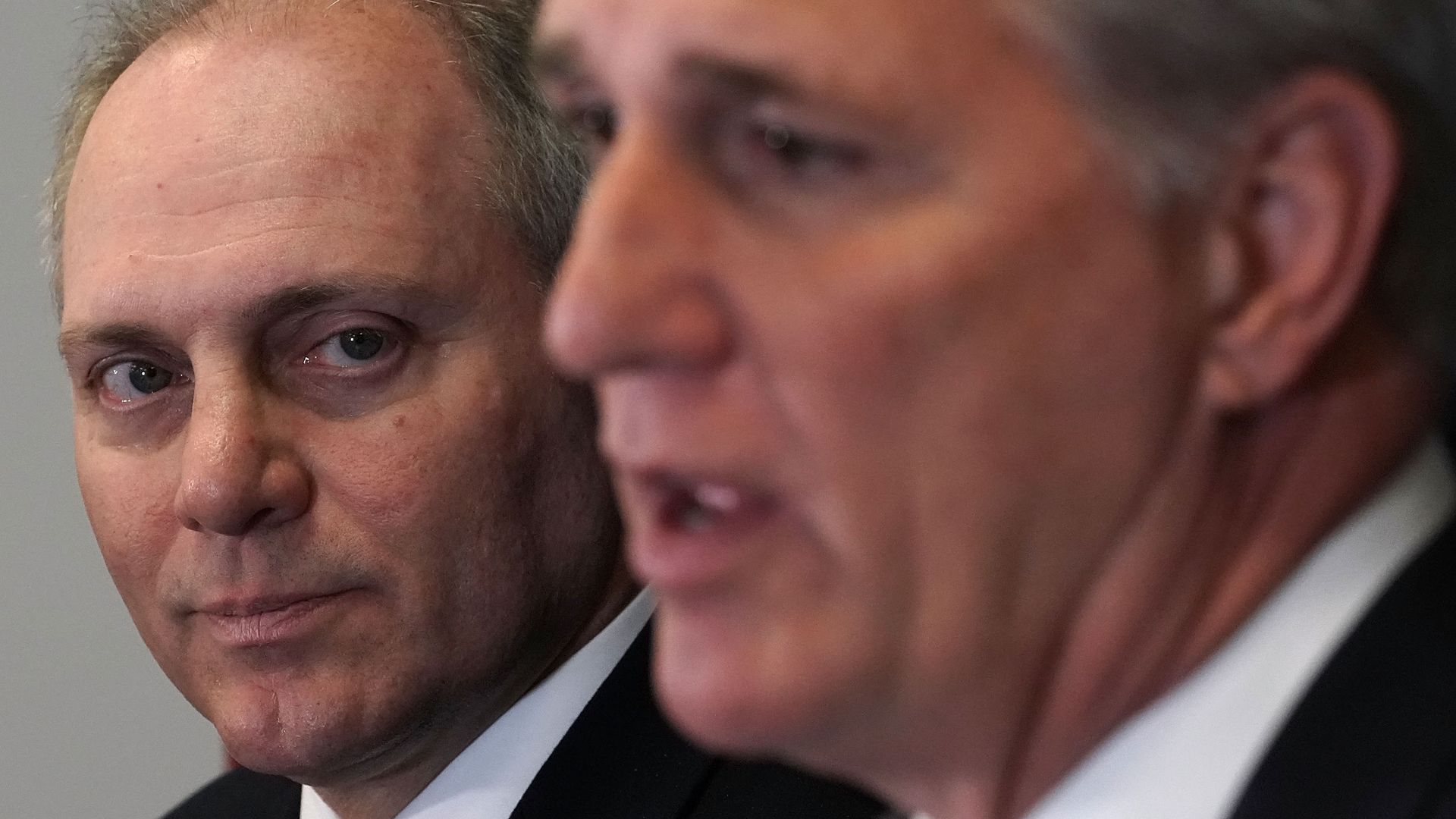 Rep. Steve Scalise in focus looking past Rep. Kevin McCarthy who is out of focus. 