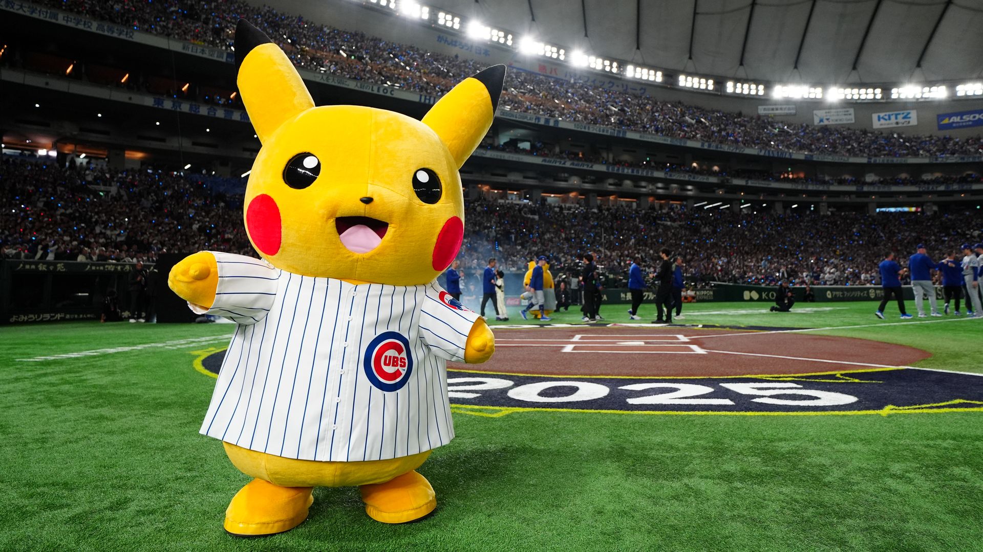 Photo of a stuffed yellow bear in a baseball jersey. 