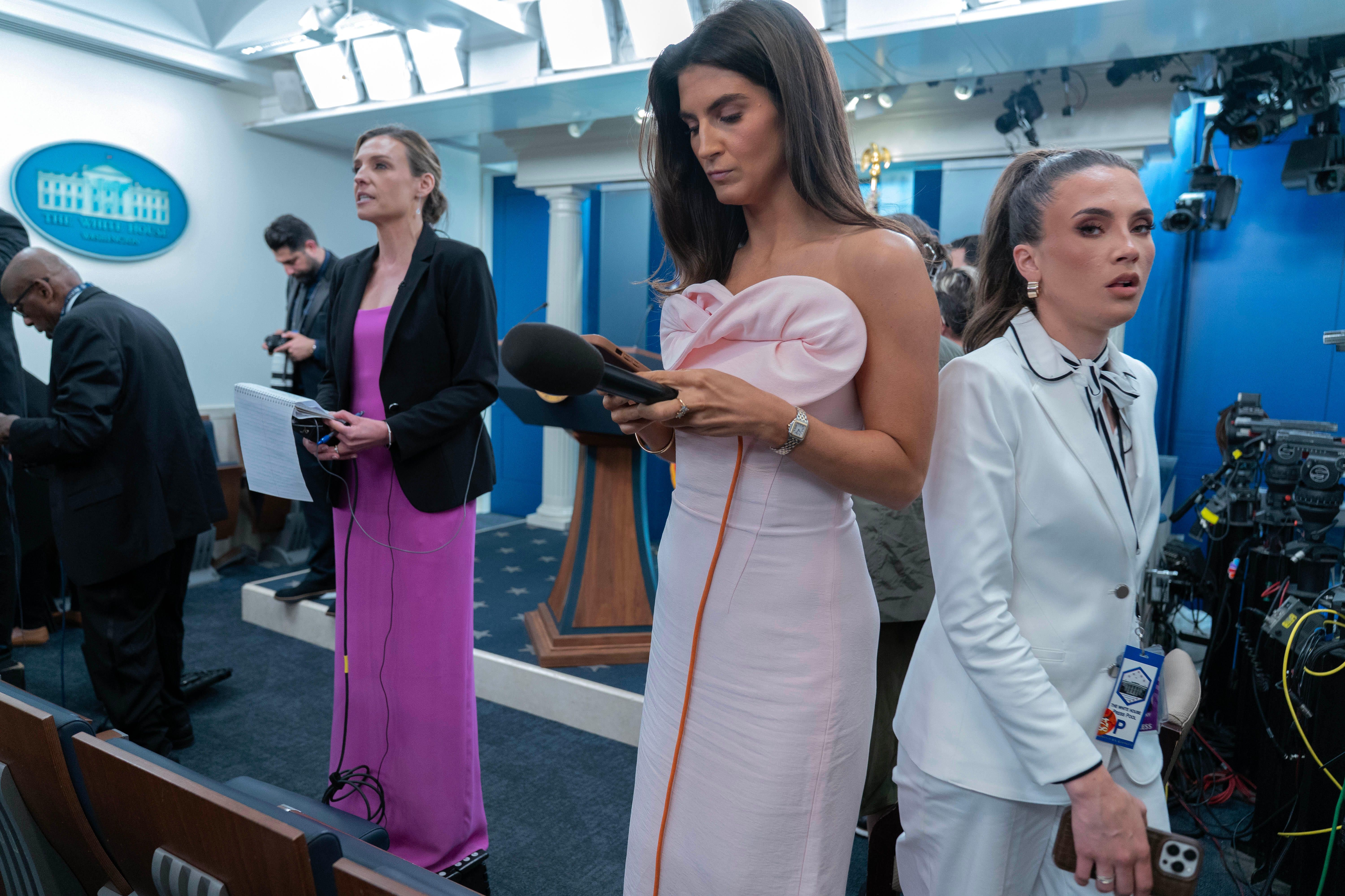Reporters dressed in evening gowns — including CNN's Kaitlan Collins — wait for President Trump to speak in the White House briefing room late Saturday night.