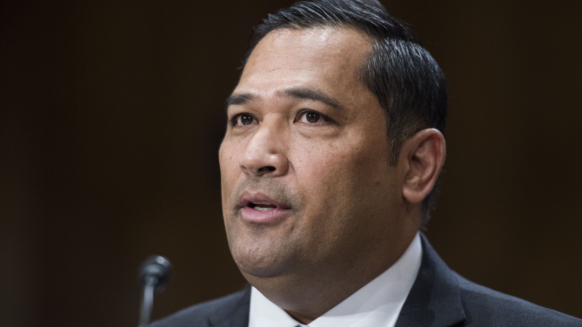 Bulatao sits in a suit and tie