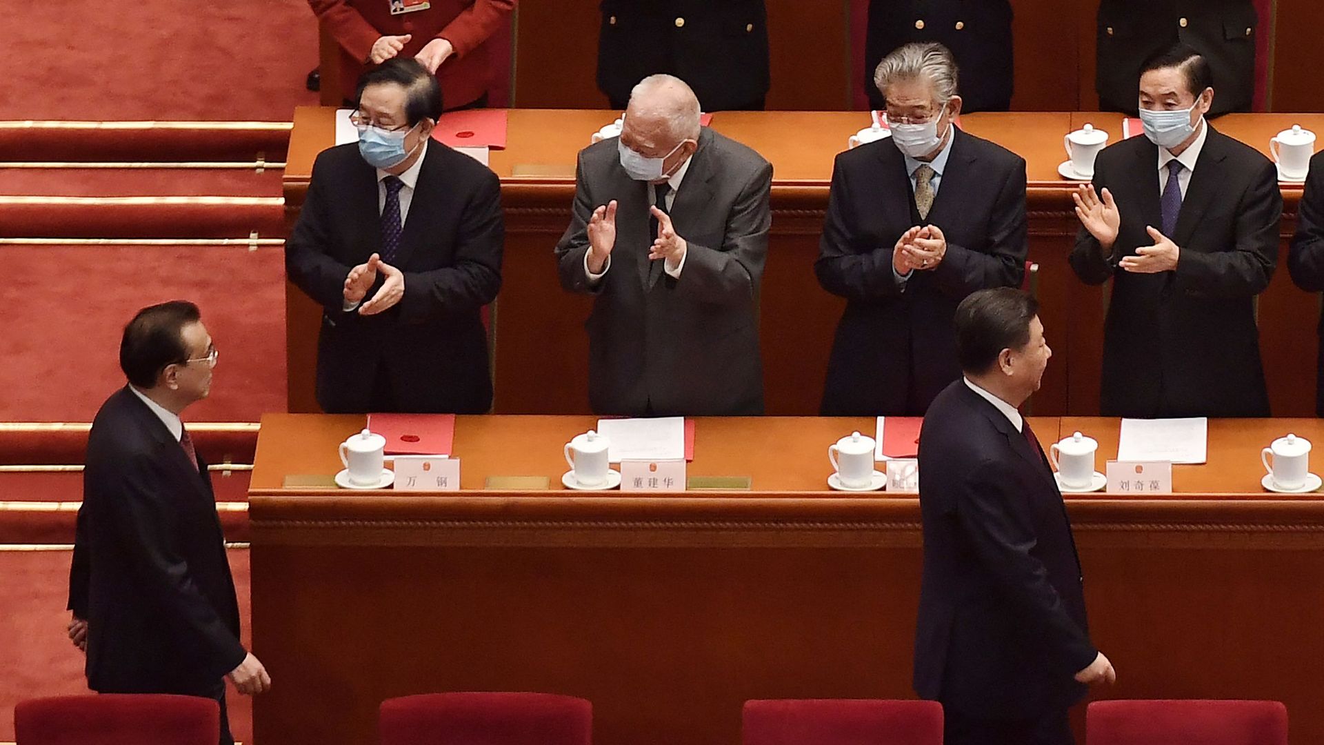 China's President Xi Jinping (R) and Premier Li Keqiang are applauded by delegates in the Beijing Parliament on March 11