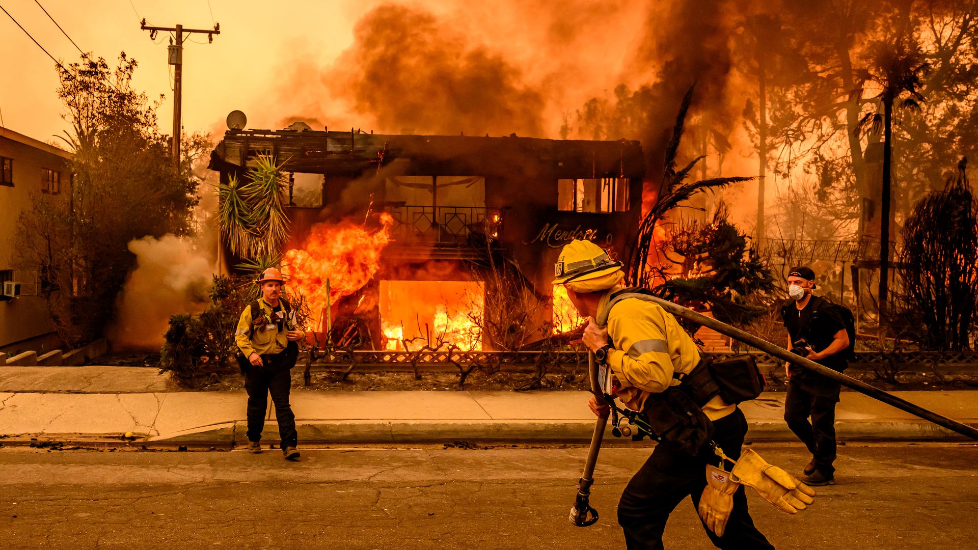 Firefighters work the scene as an apartment building burns during the Eaton fire in the Altadena area of Los Angeles county, California on January 8, 2025. 