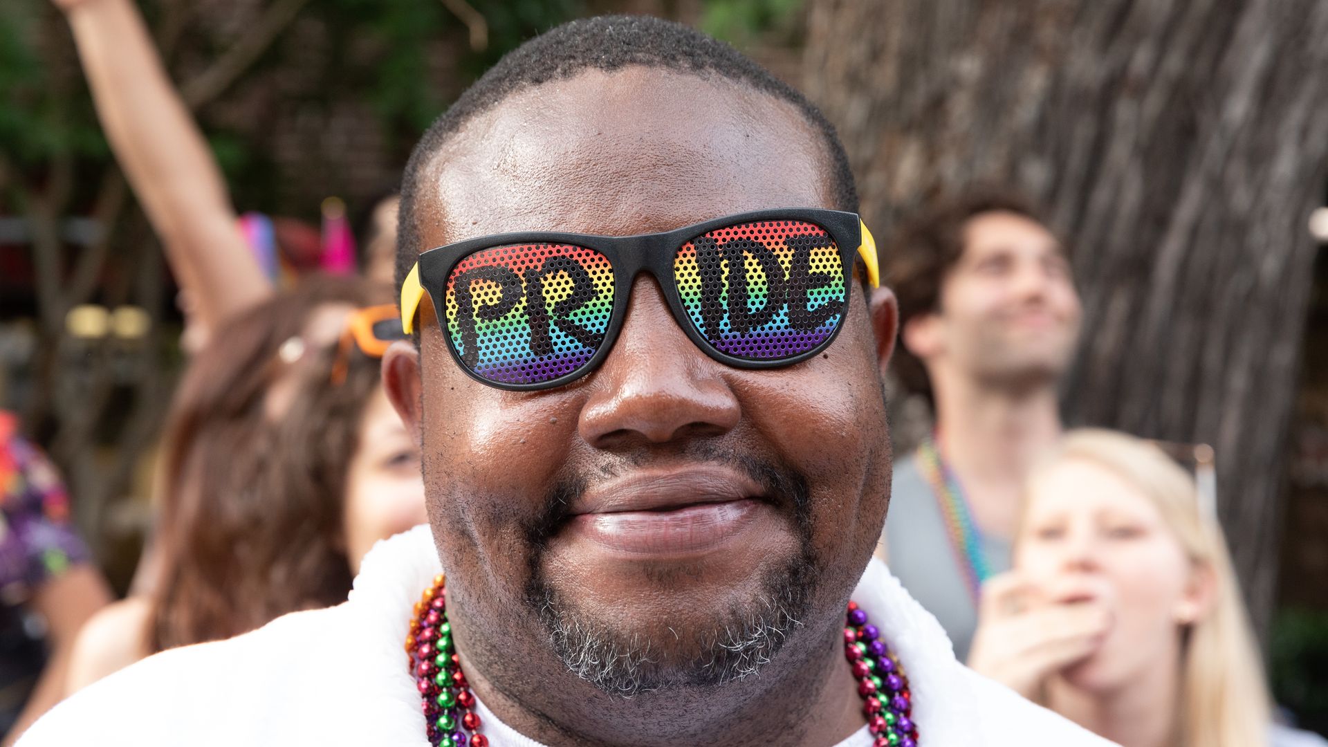 A person wearing rainbow pride glasses.