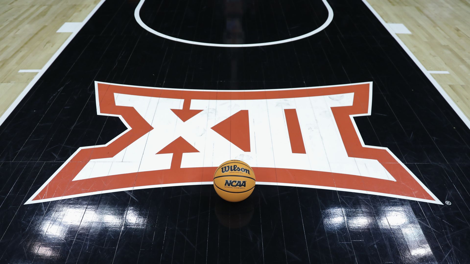 The Roman numerals for 12 on a basketball court with a basketball on the ground in front of them.