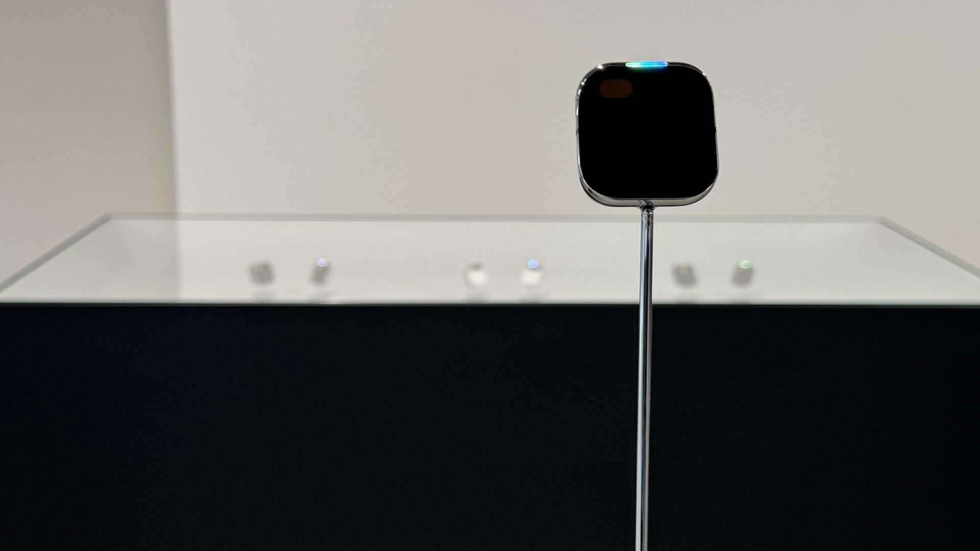 A picture of Humane's Ai Pin in front of a display case.