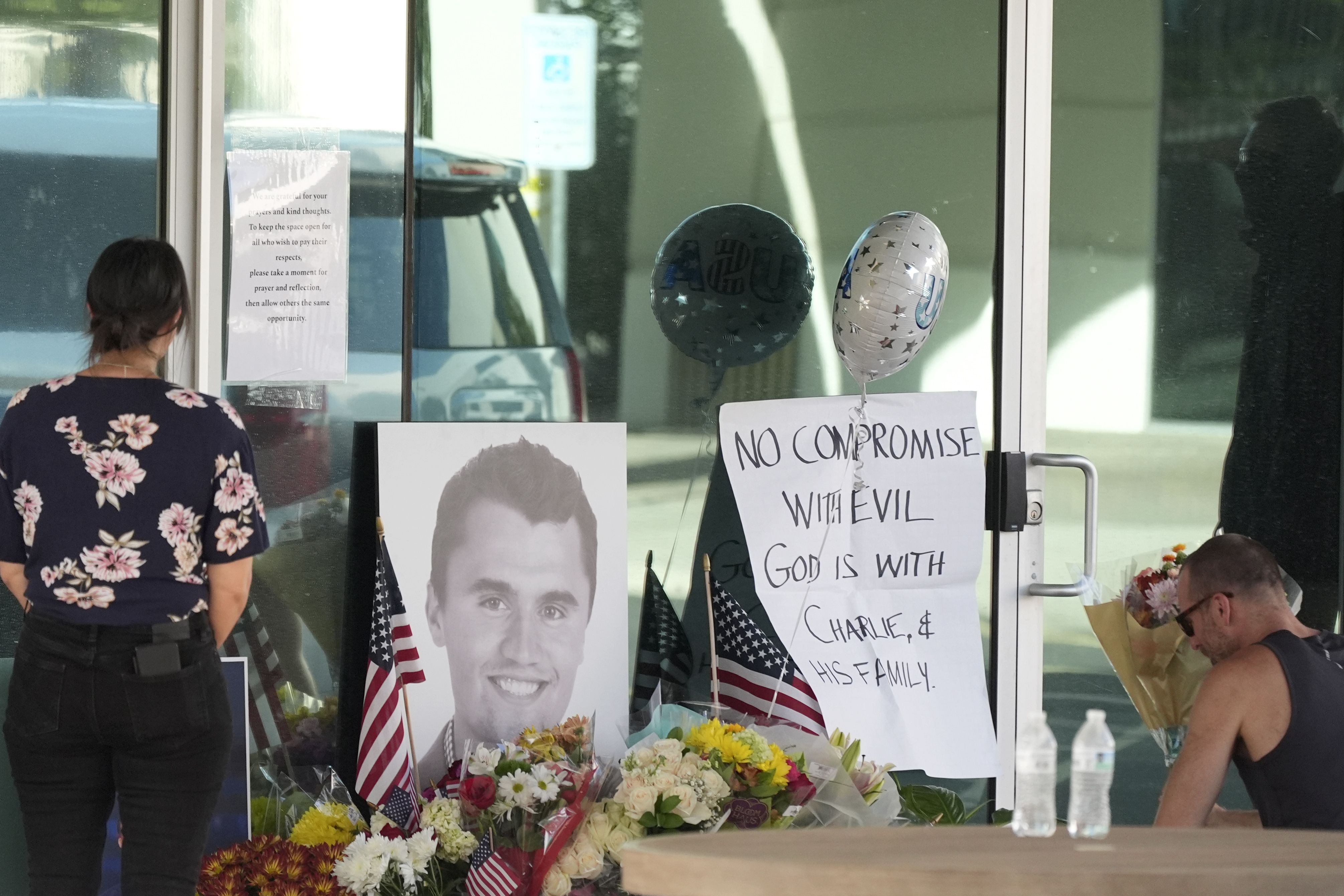 Well-wishers pay their respects at a makeshift memorial for Charlie Kirk at the national headquarters of Turning Point USA. 