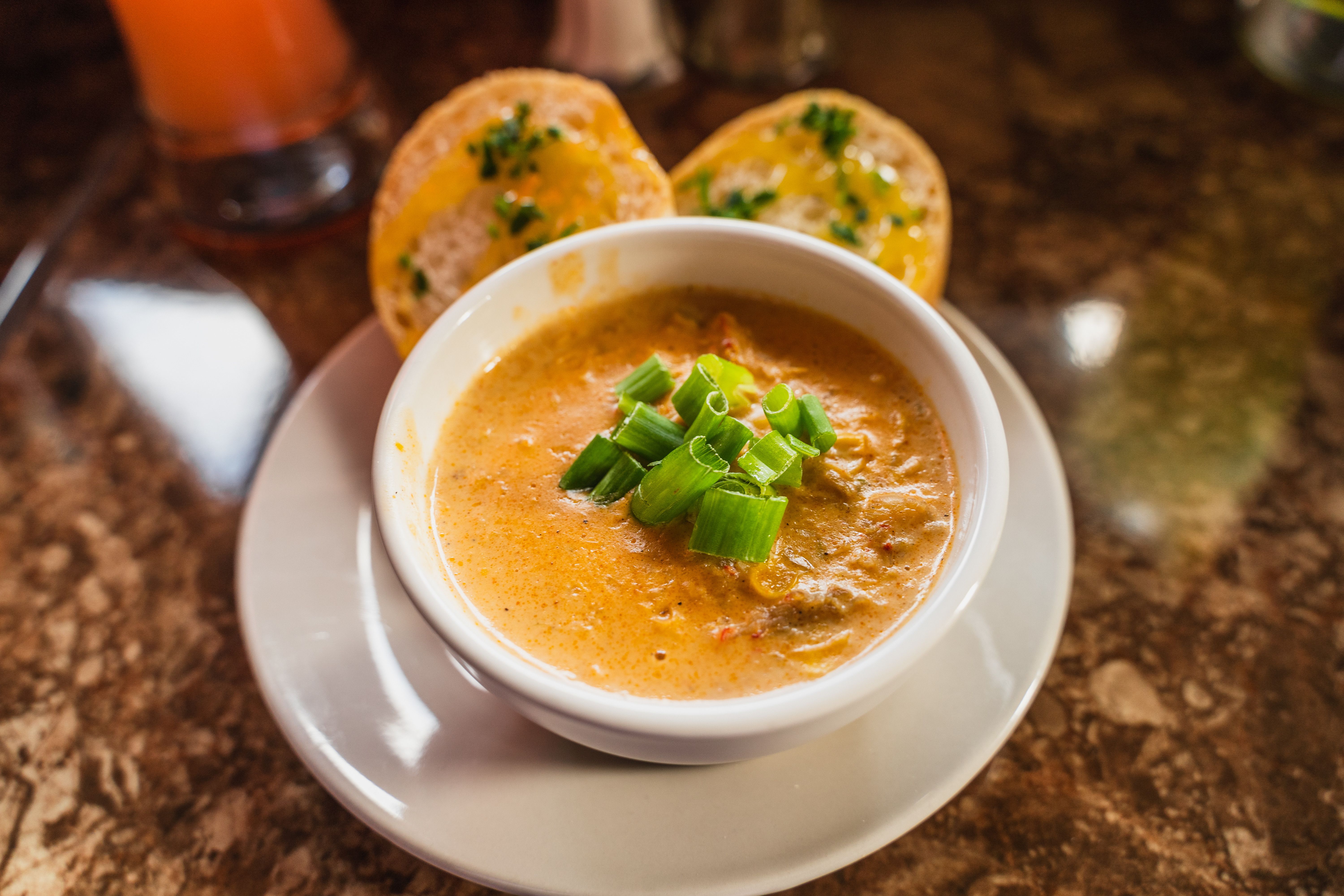 Photo shows bisque in a bowl served with bread