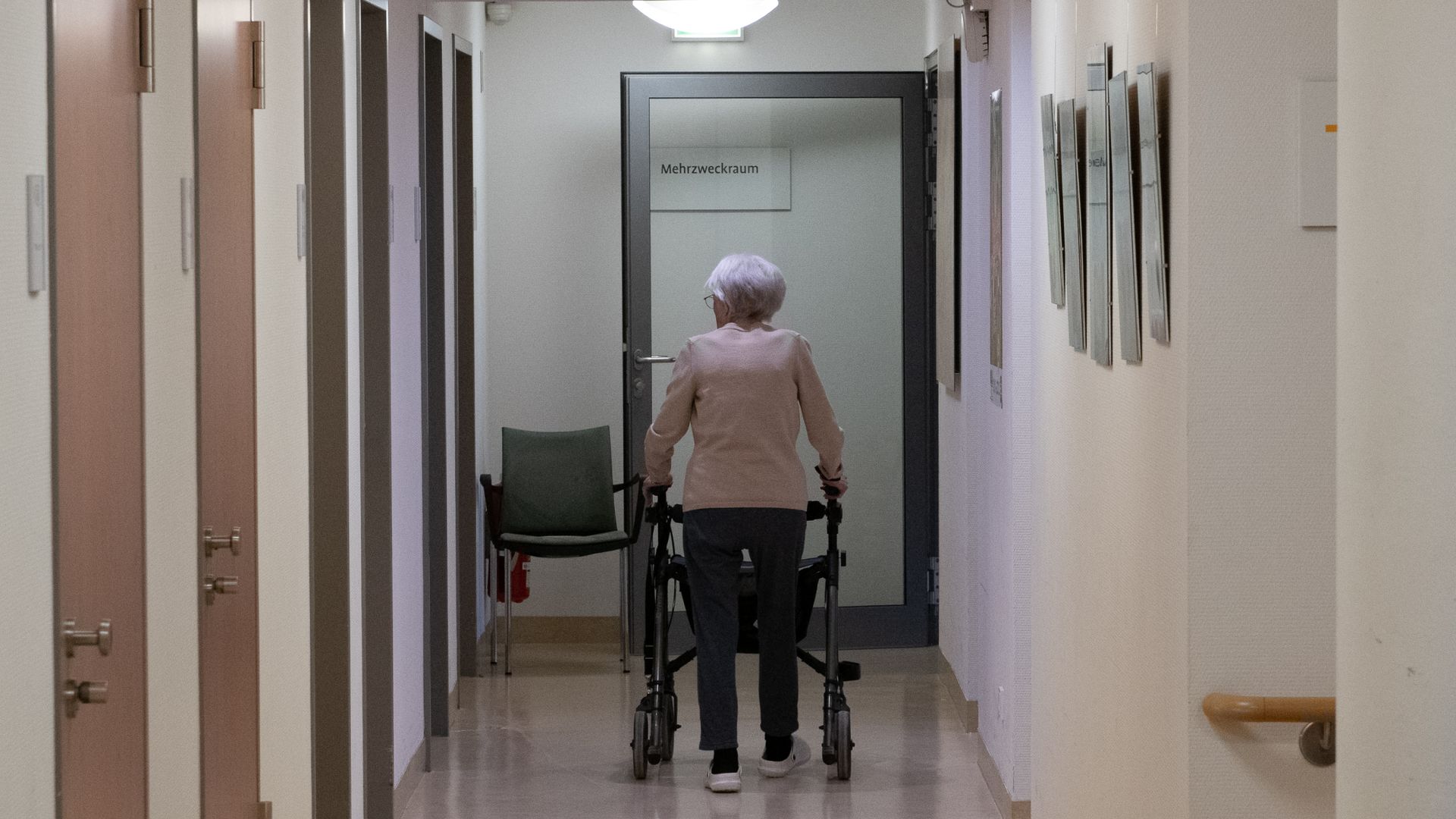 Senior citizen walking down hallway in walker