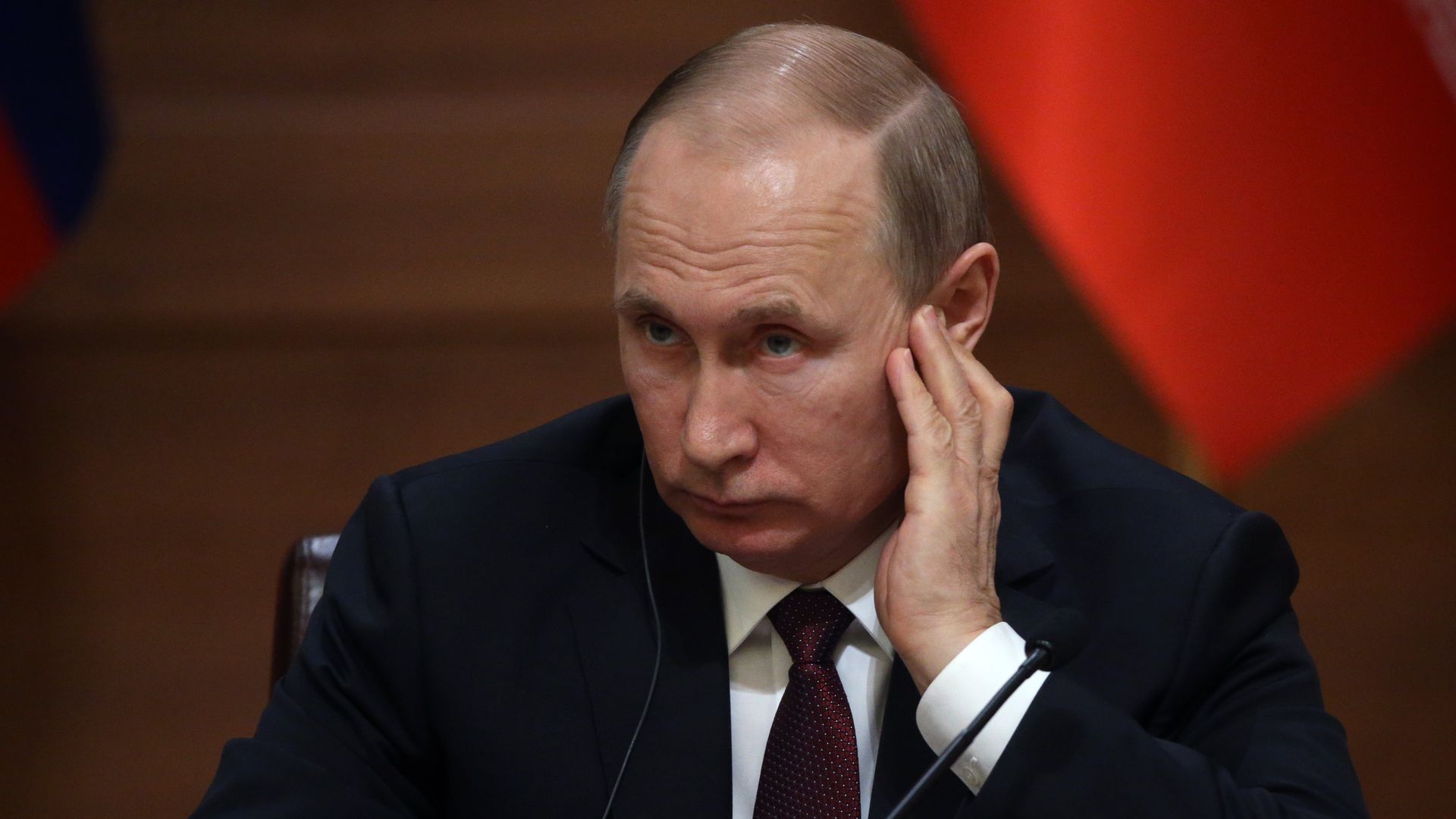 Vladimir Putin listens to a headset.