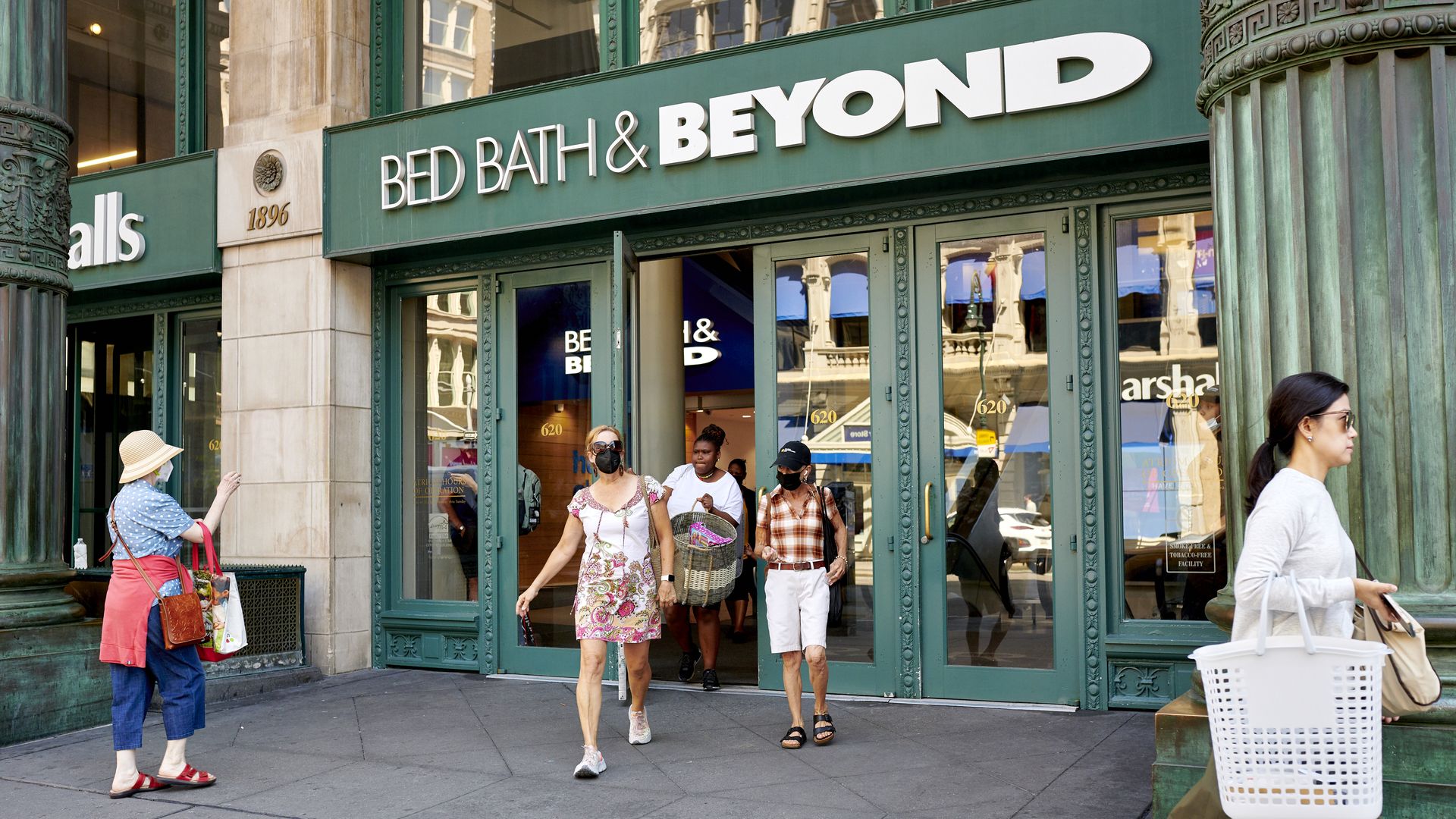 Bed Bath & Beyond store front with shoppers walking out the doors