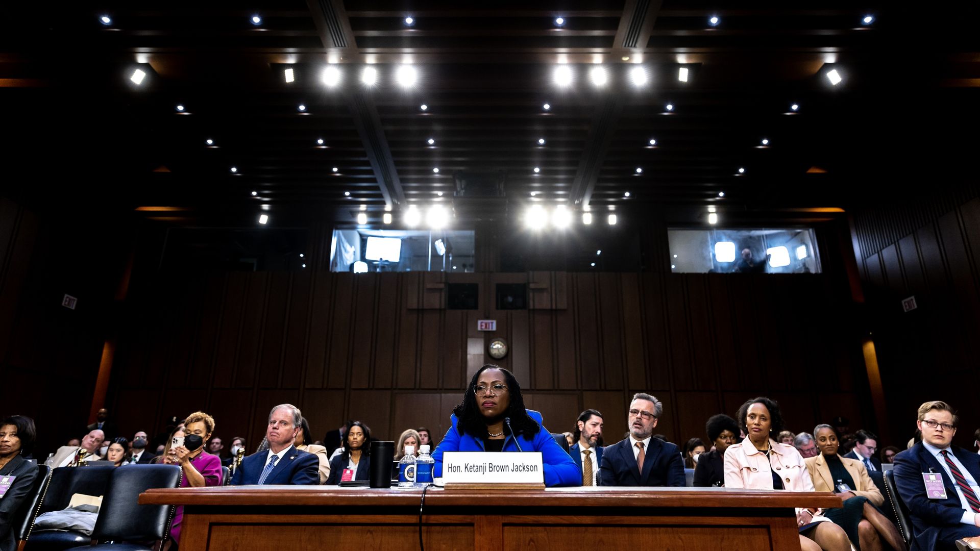 Photo of Ketanji Brown Jackson in a blue suit jacket as she sits in front of an audience