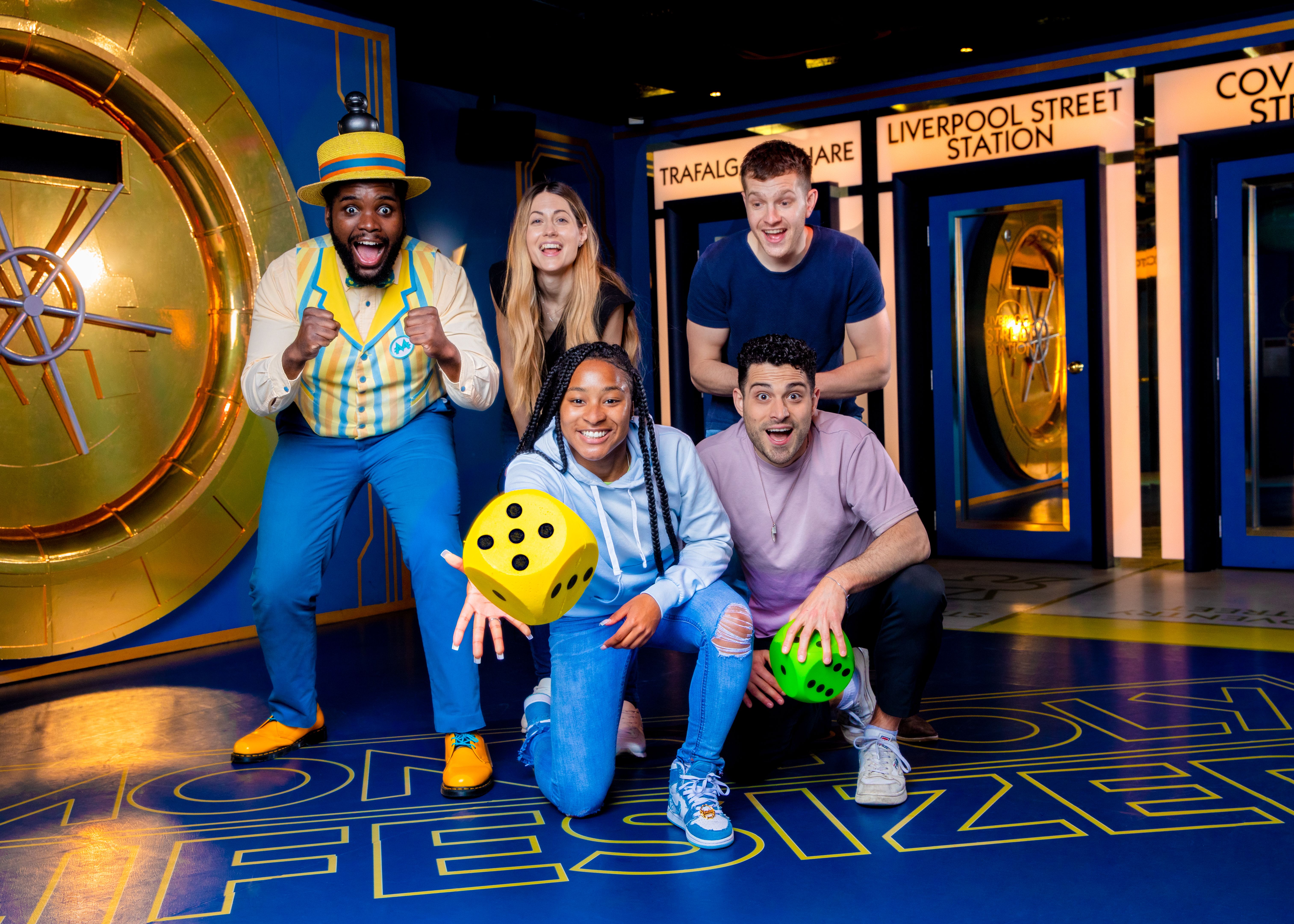A girl rolls a dice during a game of lifesize Monopoly