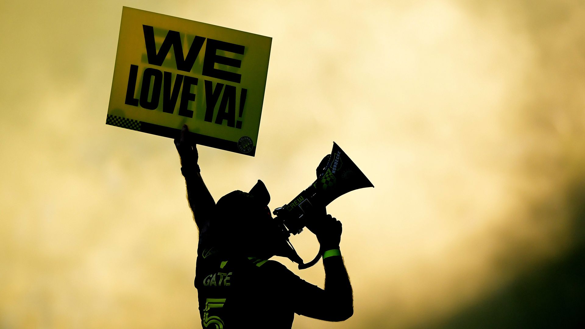 A Columbus Crew fan holds up a sign reading, "We Love Ya!"